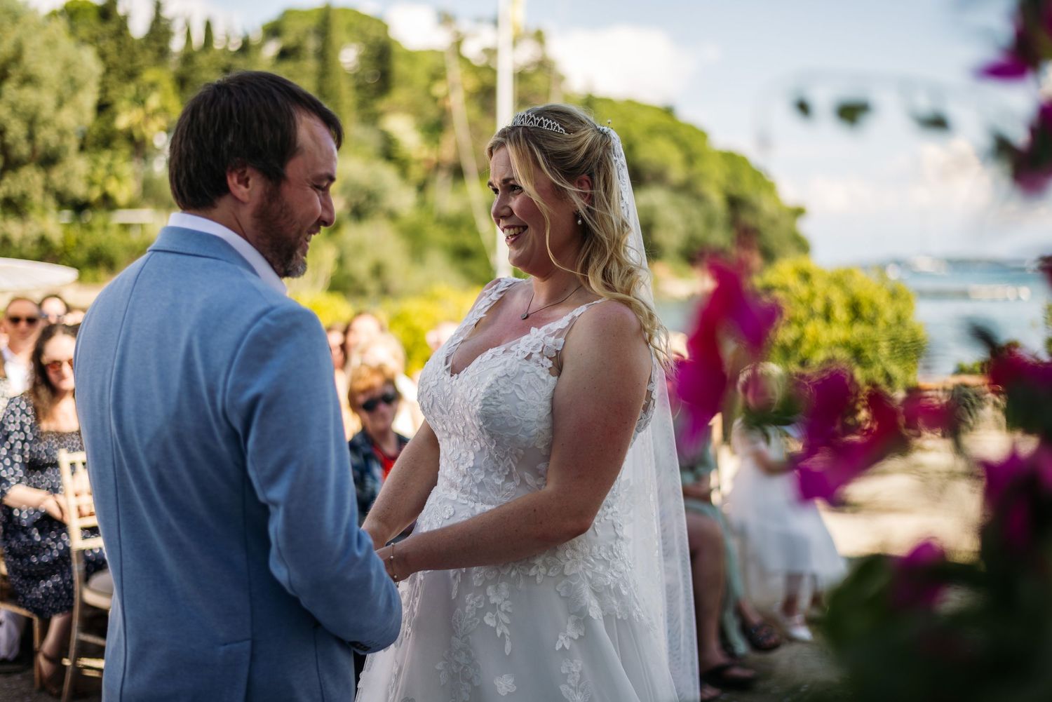 A beautiful outdoor wedding ceremony set against a Mediterranean-style church with pink bougainvillea.