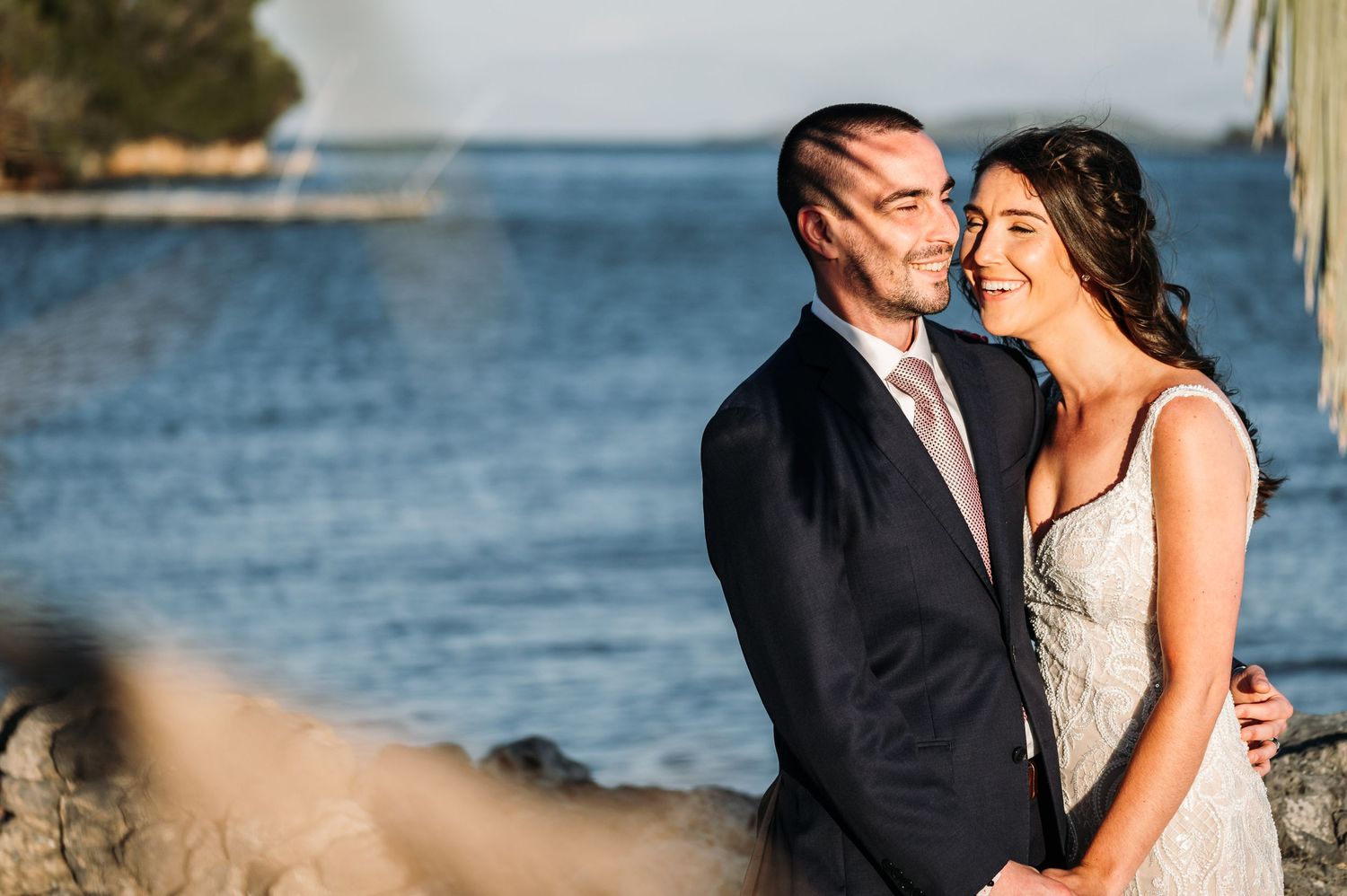 Newlyweds share tender moments during their waterfront photo session.