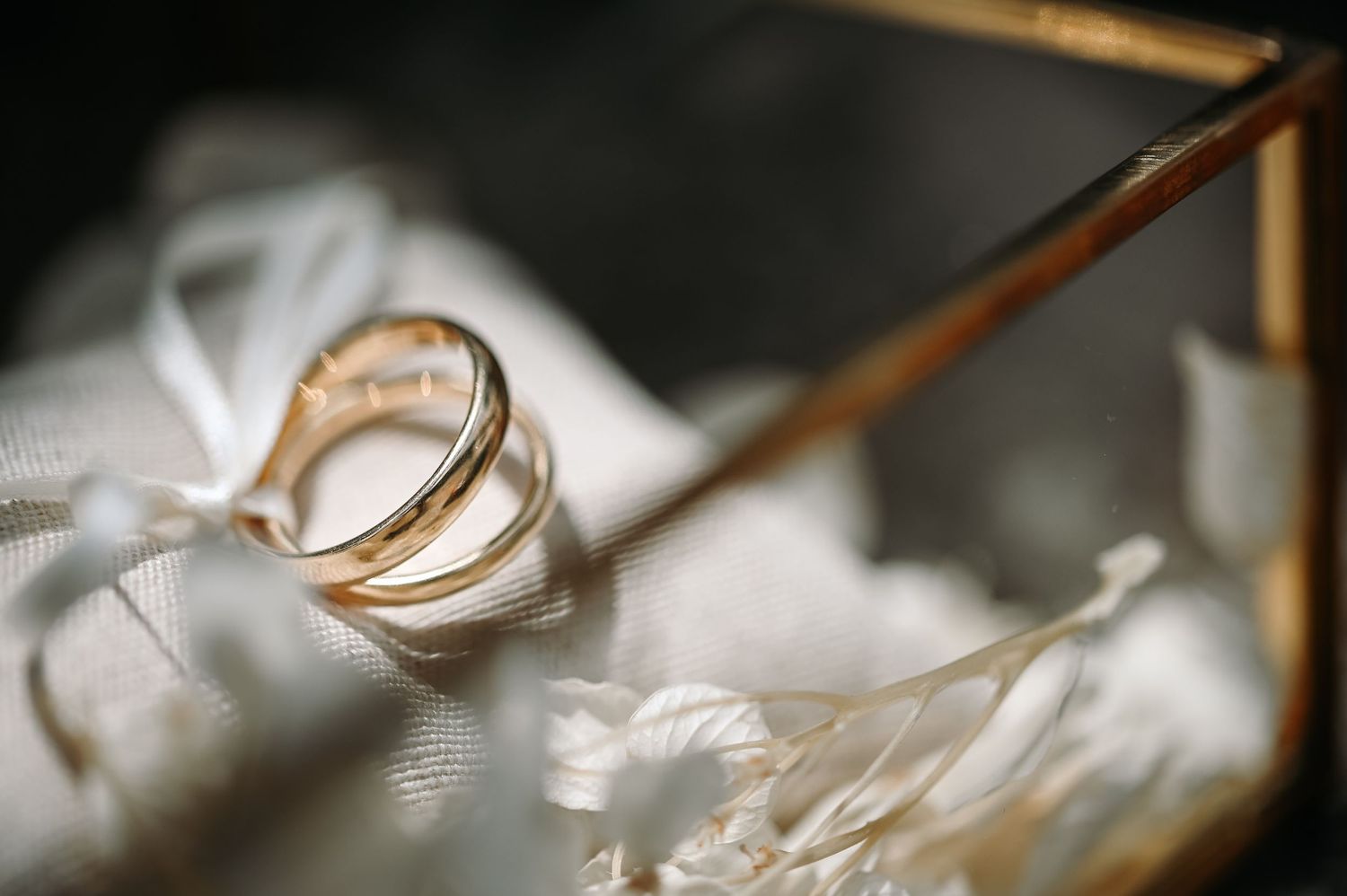 Macro detail shot of wedding rings with soft bokeh background.