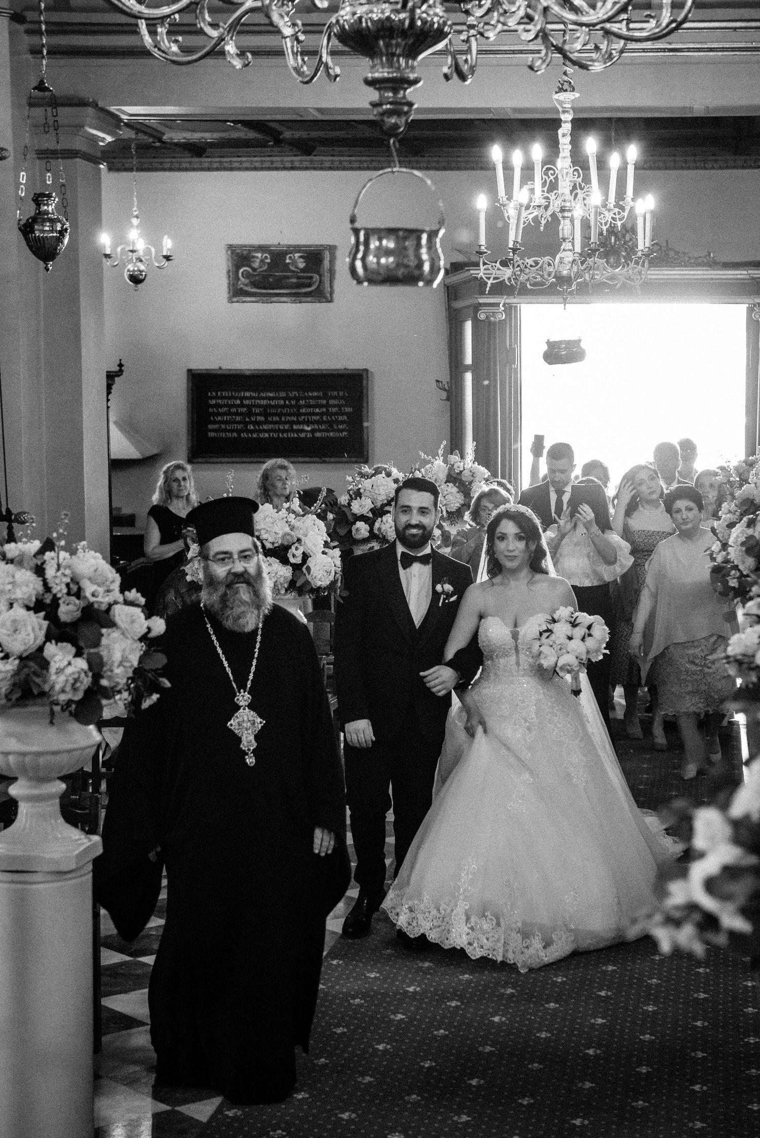 Elegant ballroom wedding reception with chandeliers and formal table settings.