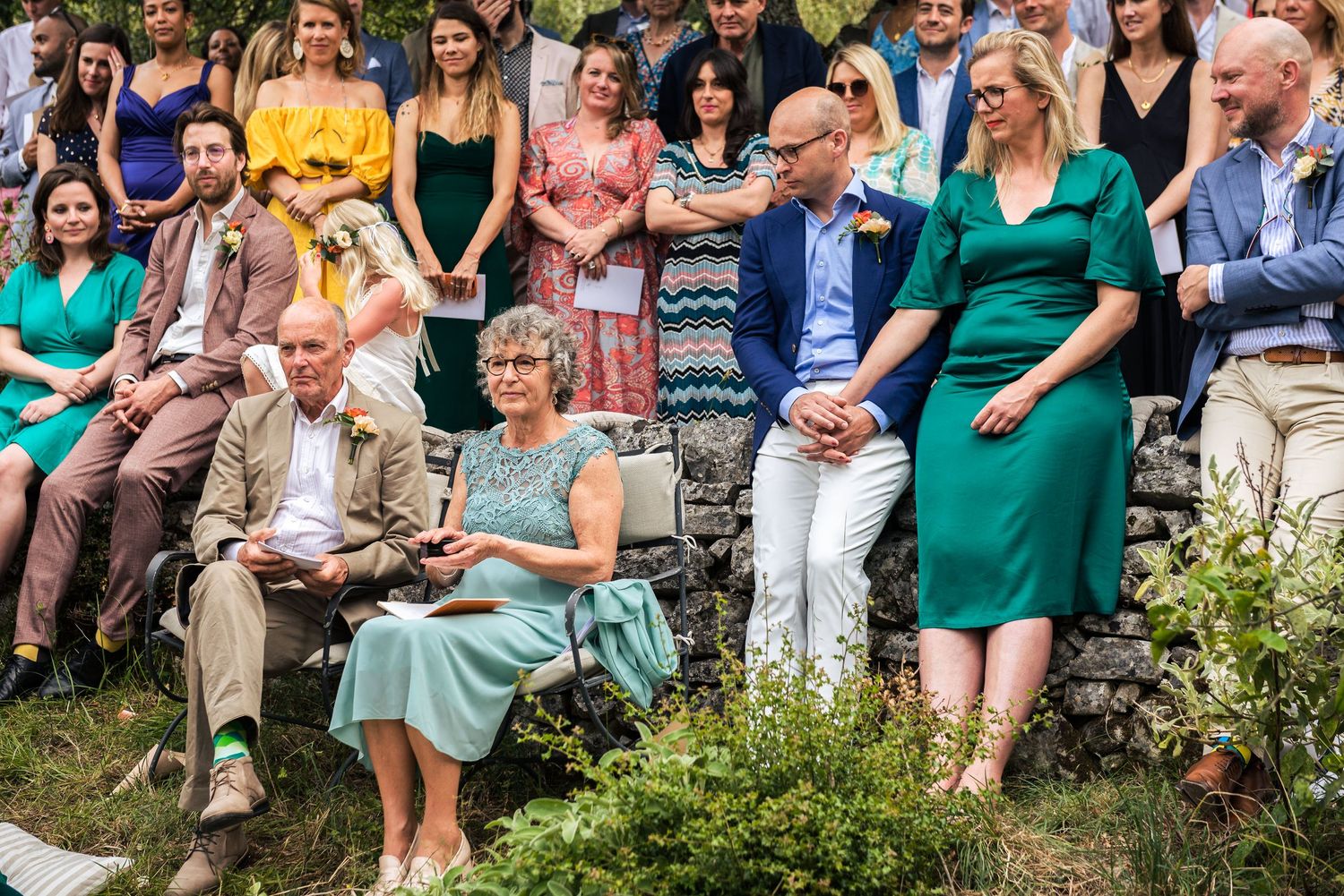 Panoramic view of wedding guests seated outdoors for a garden ceremony.