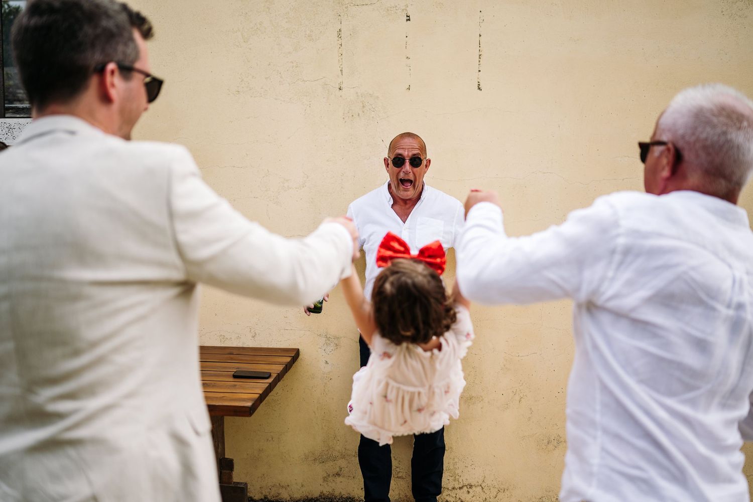 Wedding party members in white shirts share joyful moments indoors.