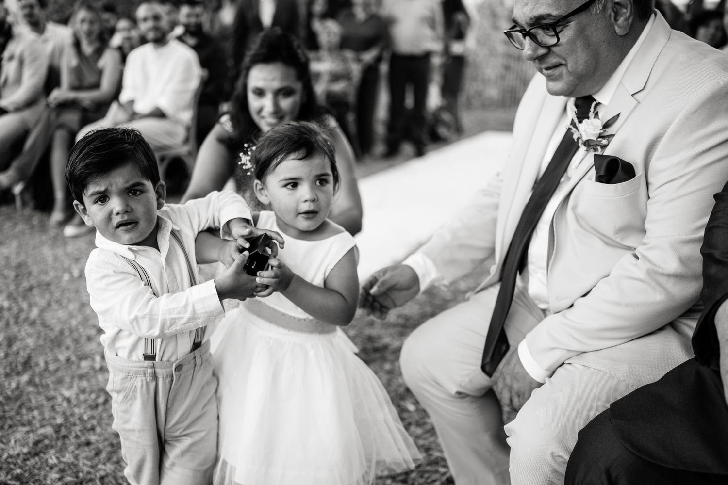 Black and white candid moments from an outdoor wedding celebration.