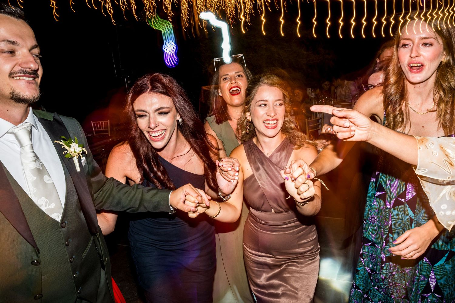 Energetic wedding party dancing and celebrating on the dance floor.