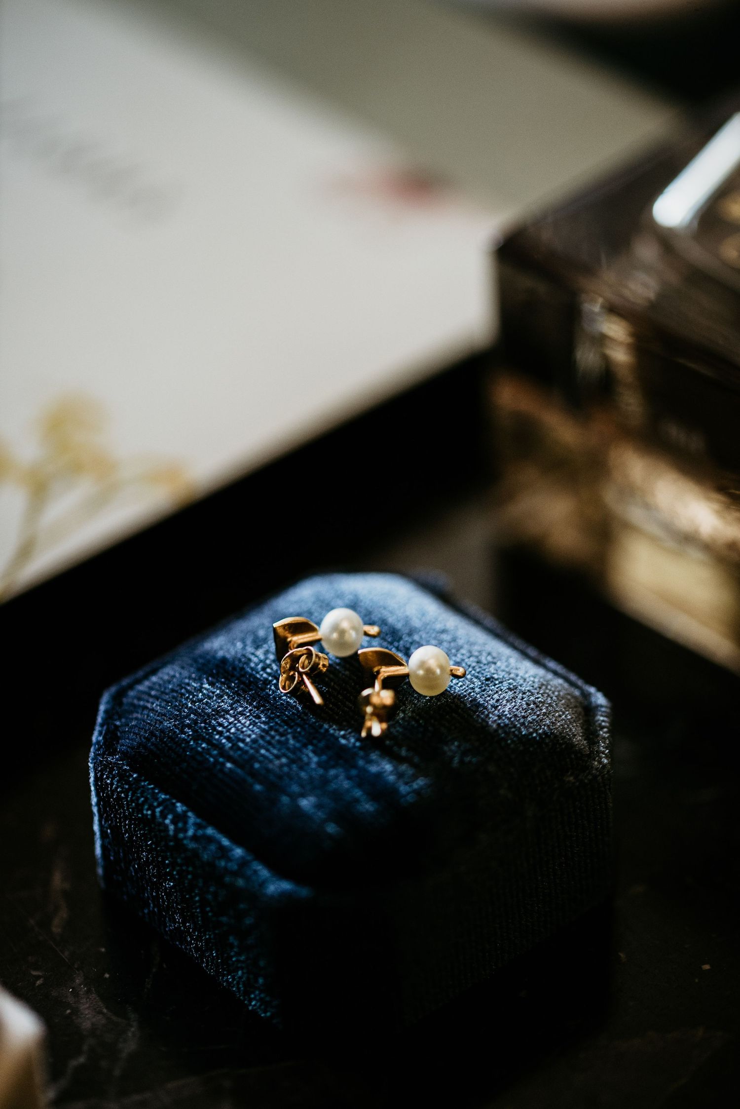 Close-up of wedding rings on dark blue velvet texture.