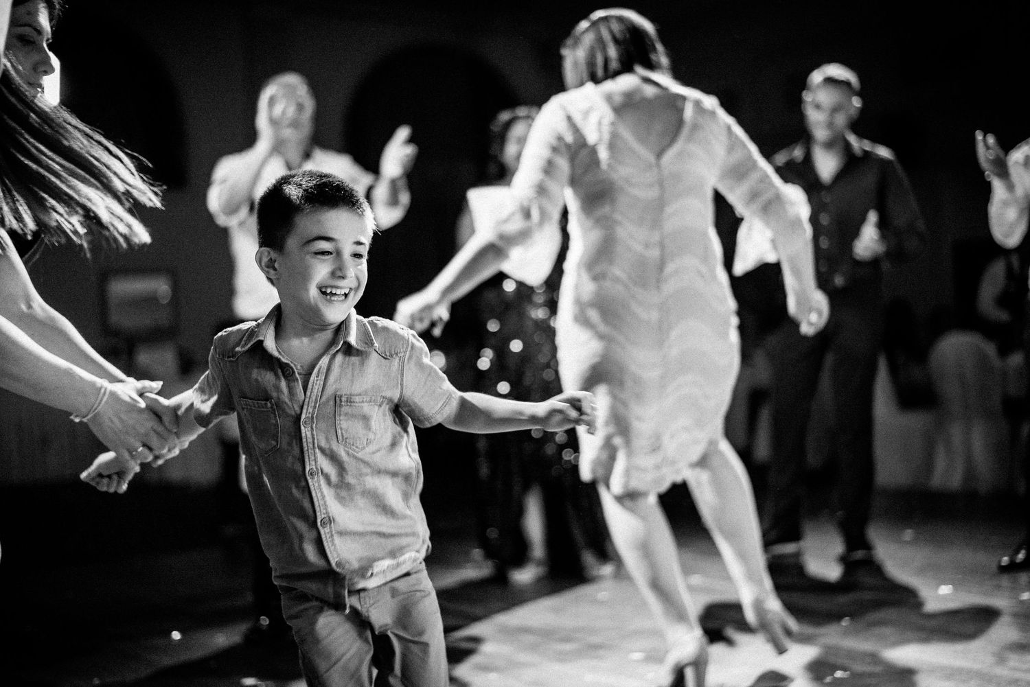 Dynamic black and white shots of guests dancing and celebrating at a wedding party.