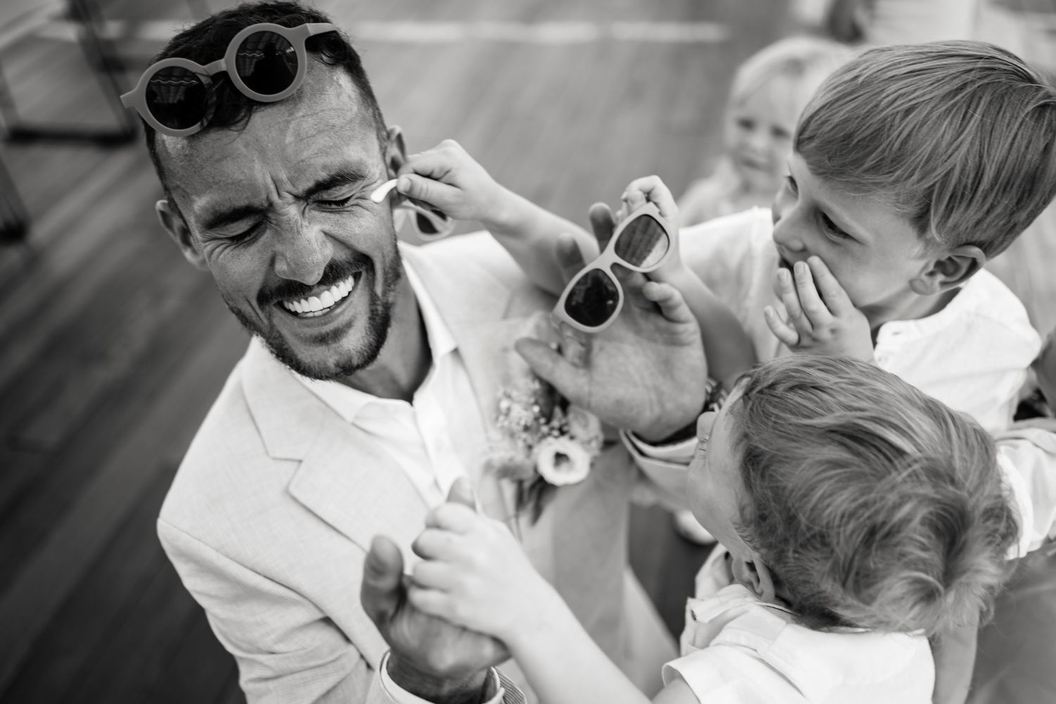 Black and white photo showing a joyful candid moment between people laughing and smiling together.