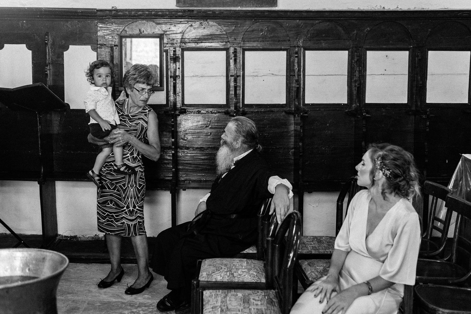 Black and white series of intimate baptism moments showing parent holding baby during ceremony.