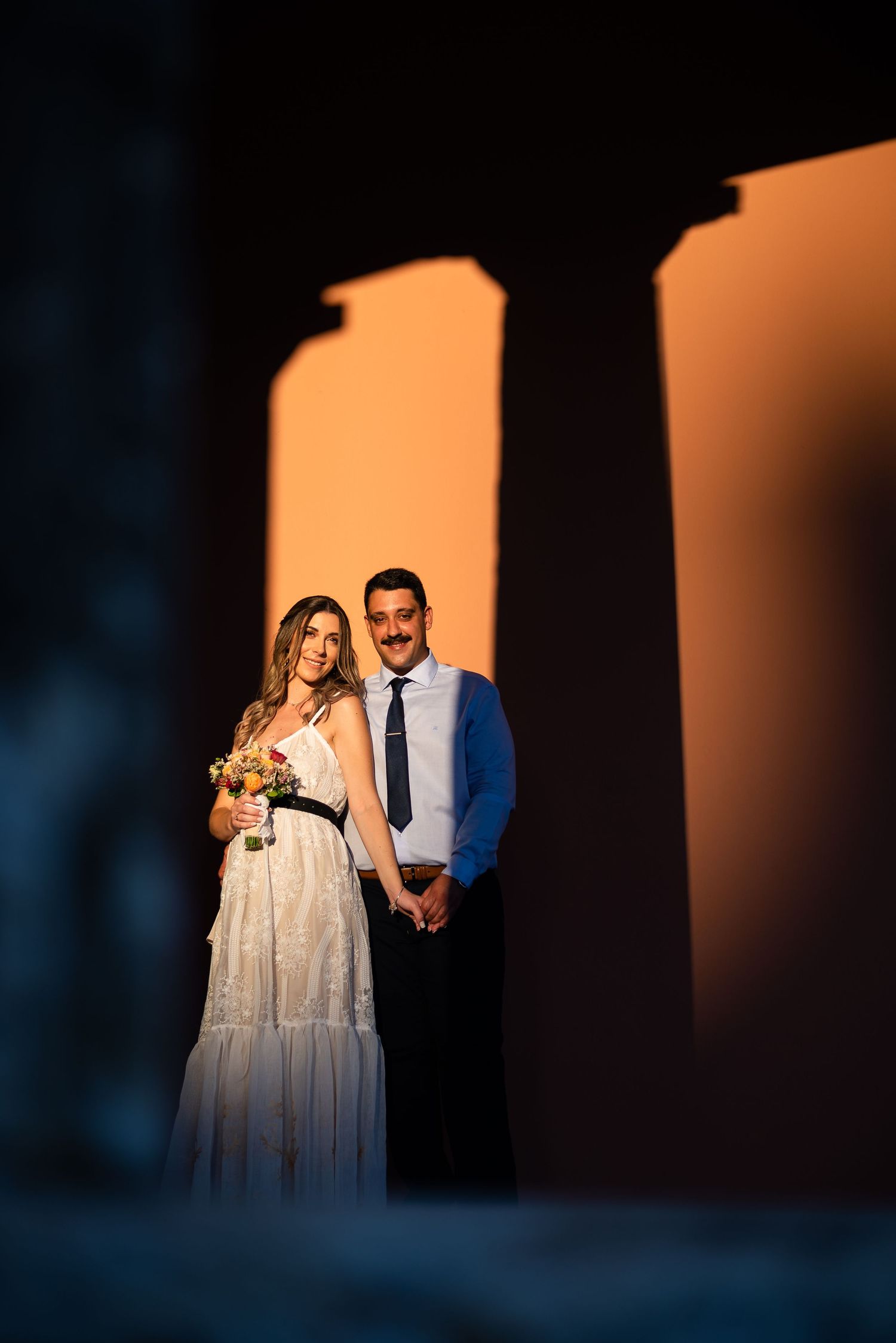 Dramatic silhouettes of a couple against an orange-lit background creating a romantic atmosphere.