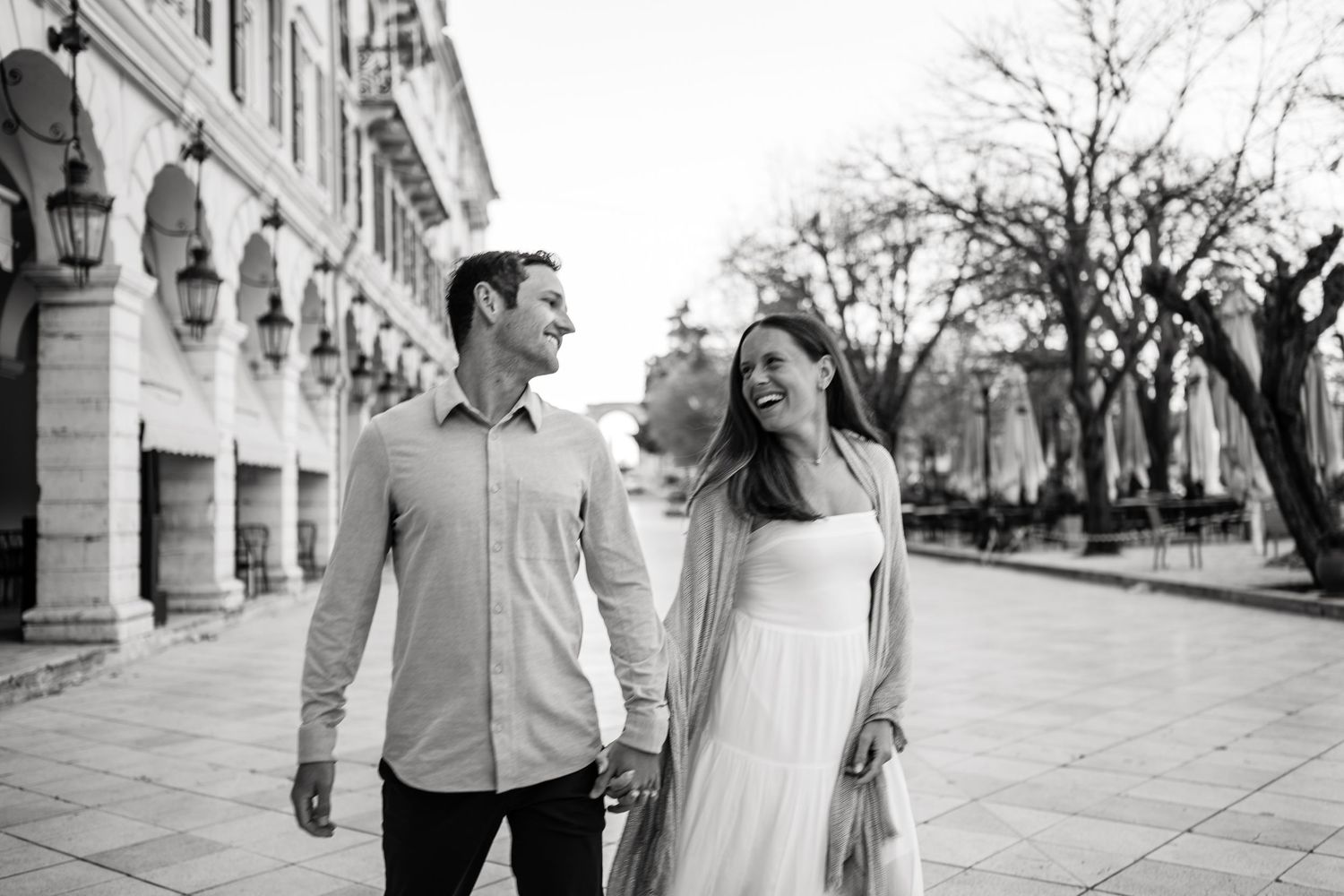 Couple walking along a classic European promenade with historic architecture.
