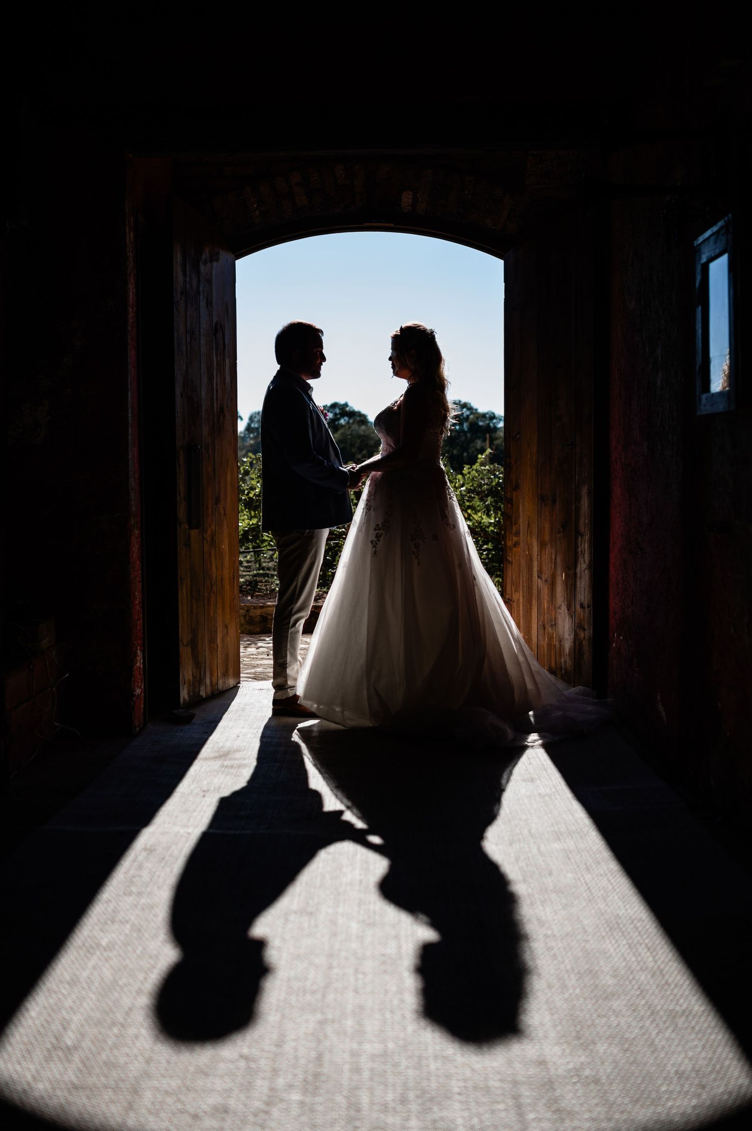 Dramatic silhouette of figures in a doorway creating long shadows on a bright floor.
