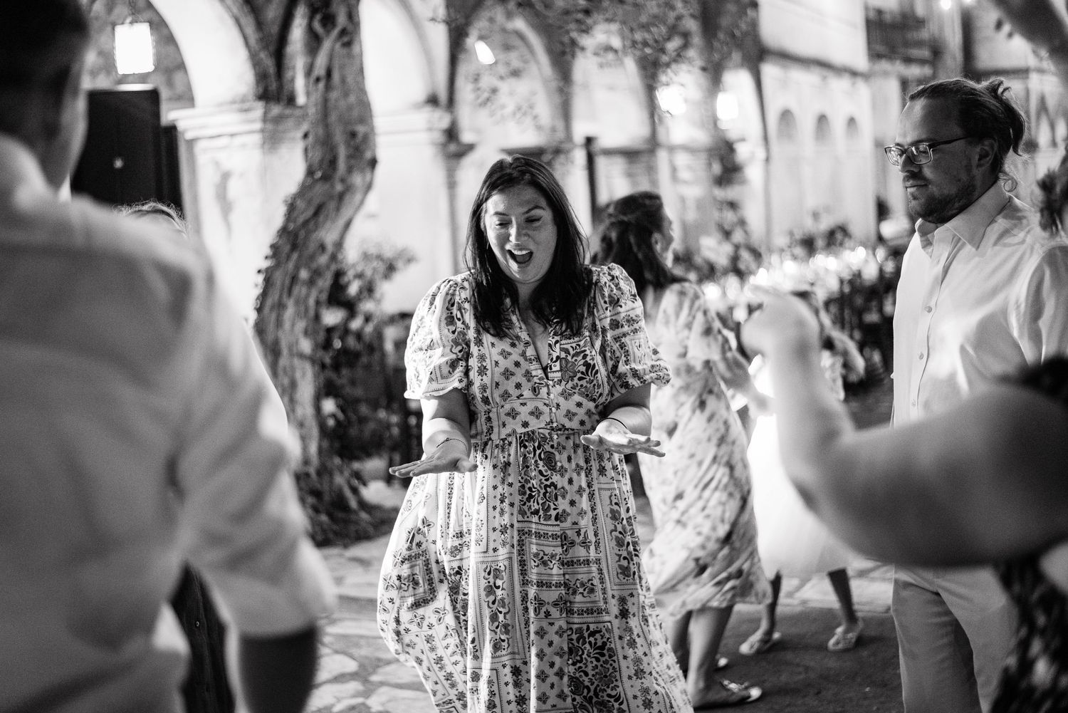 Wedding guests dancing and celebrating at outdoor reception venue.