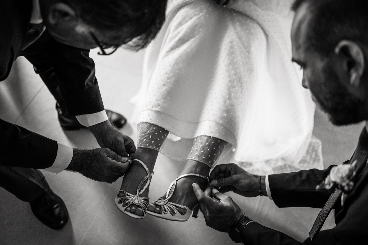 Close-up details of wedding dress preparations in black and white.