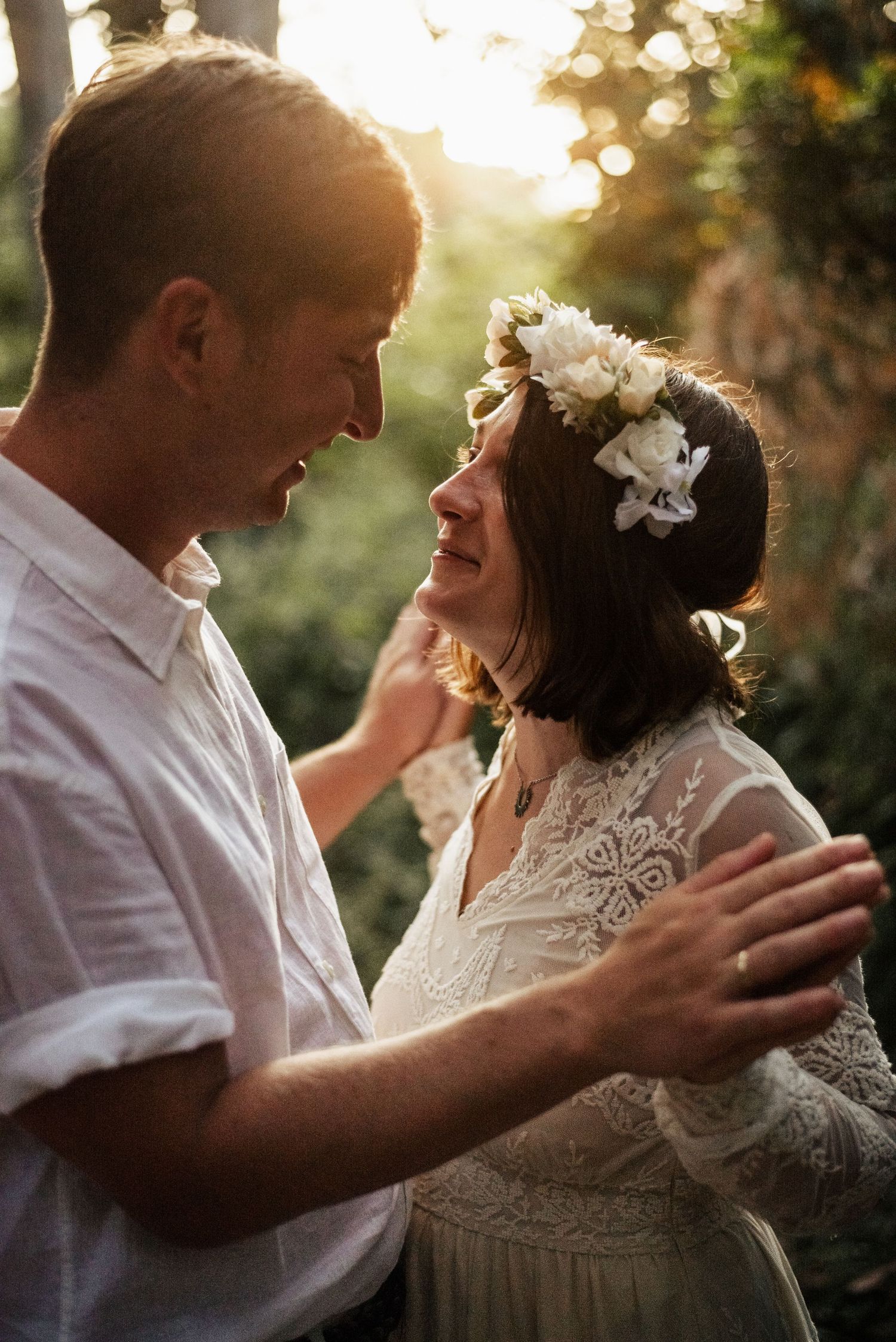 Intimate wedding moment captured during golden hour in a garden setting.
