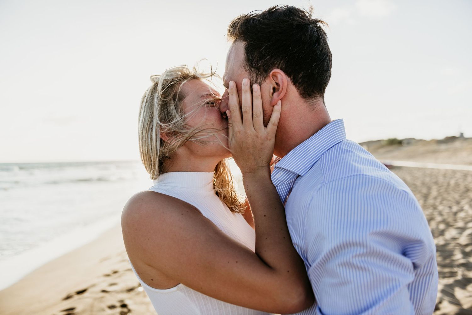 Intimate moment shared between a couple on a coastal beach.