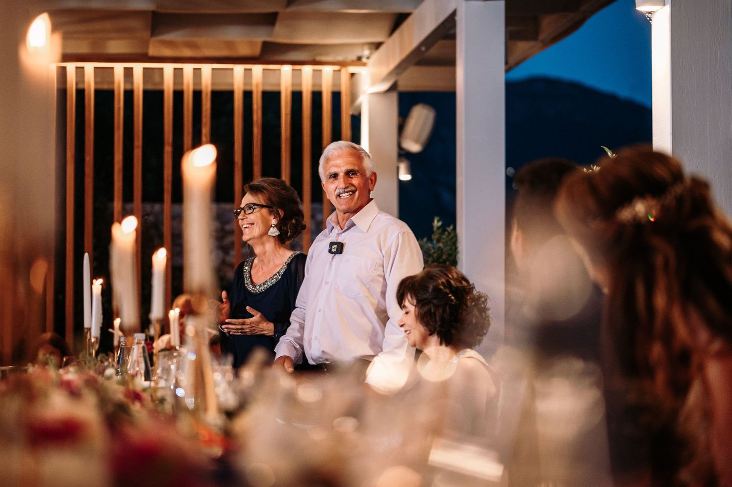 Candlelit wedding reception tables create a warm ambiance in an elegant venue.