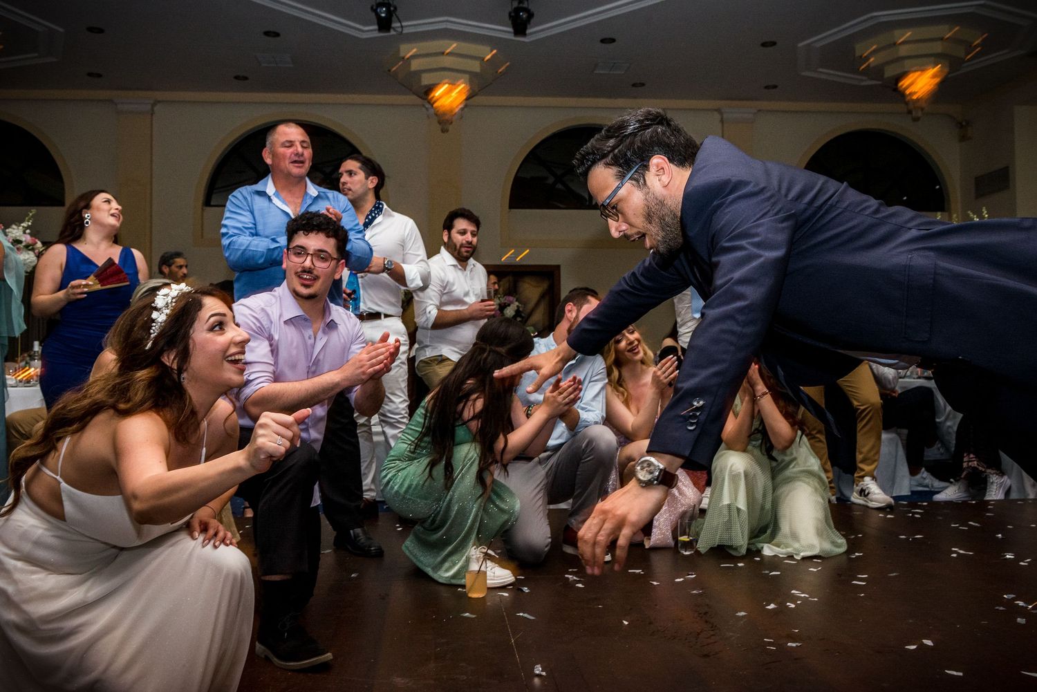 Dynamic dance floor scene with wedding guests in motion during an energetic celebration.