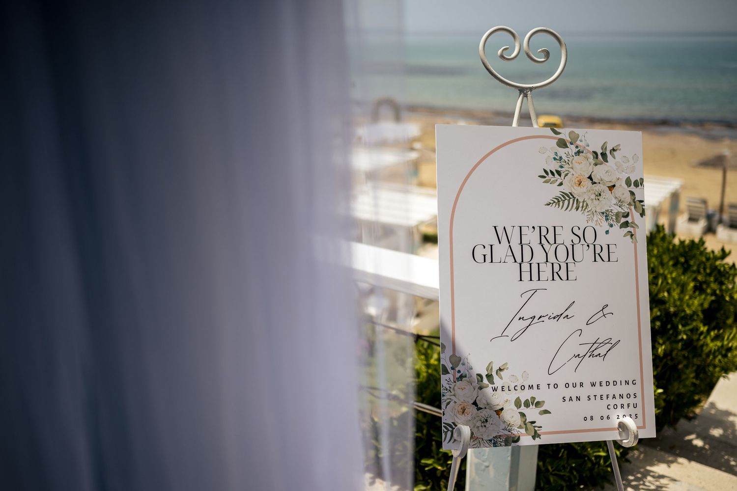 Wedding welcome sign with elegant script against ocean backdrop.