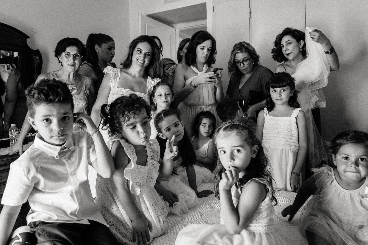 A candid black and white photo showing a group of children lined up against a wall.