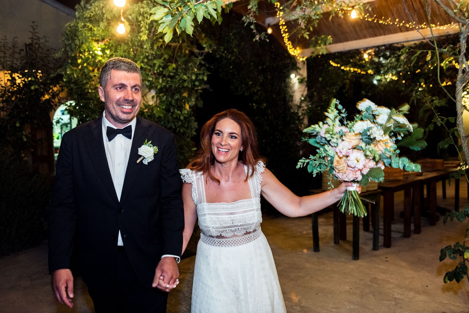 A joyful wedding celebration moment under twinkling garden lights.