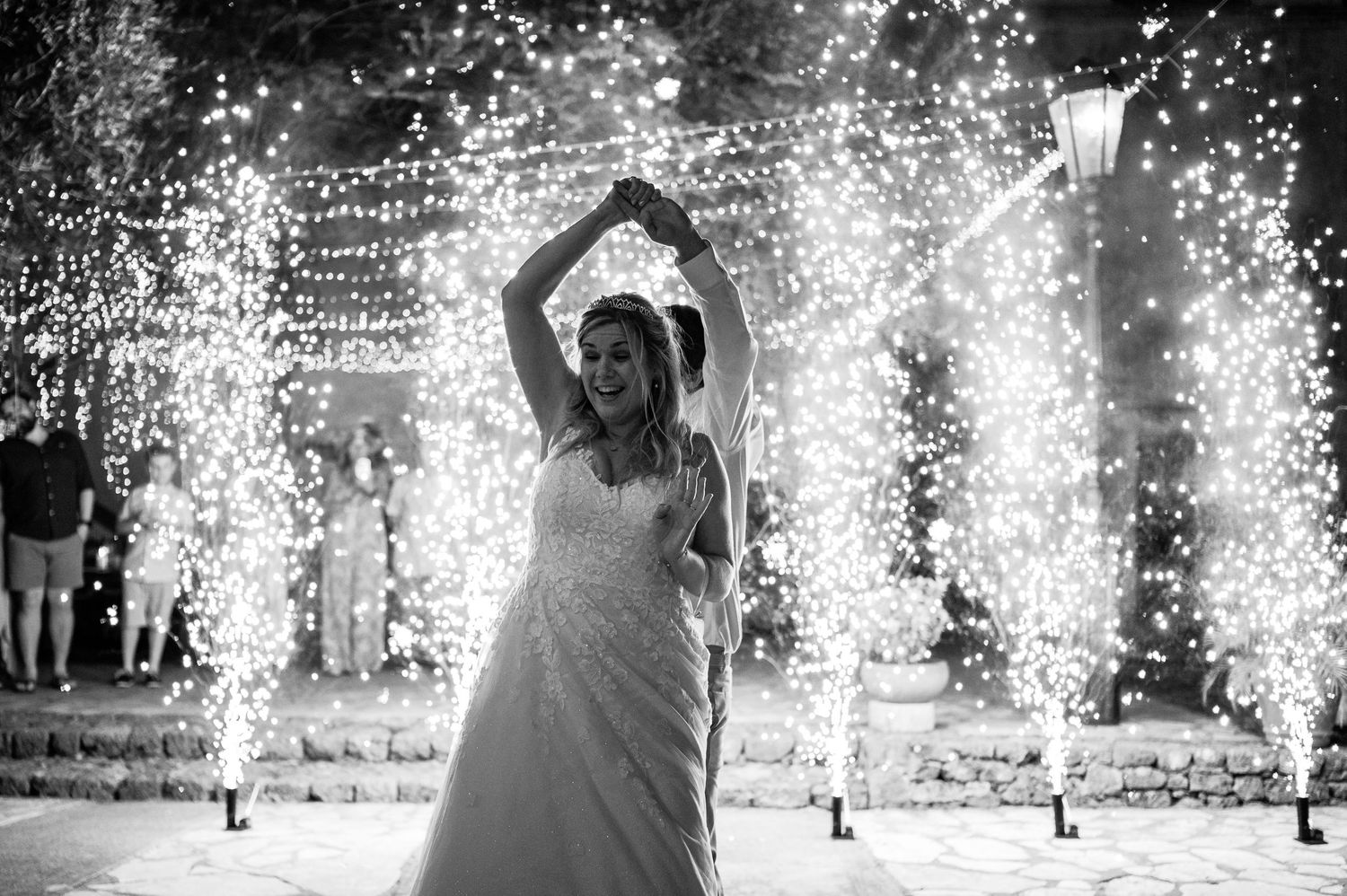 Silhouette of person dancing under sparkling lights at nighttime celebration.