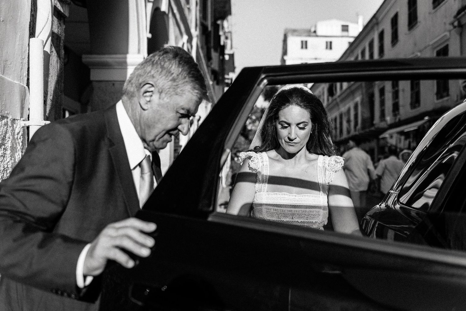 Black and white photo captures candid moments between wedding guests arriving at the celebration.