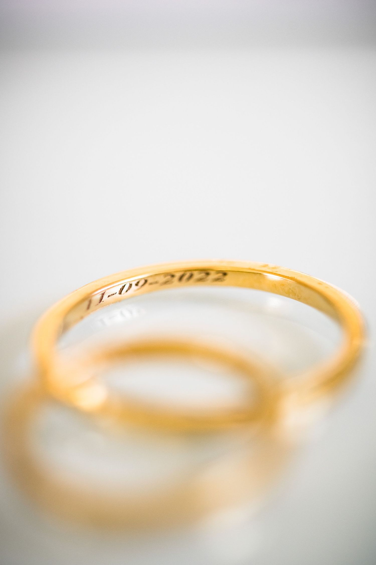Artistic macro shots of a gold wedding band with soft focus and white background.