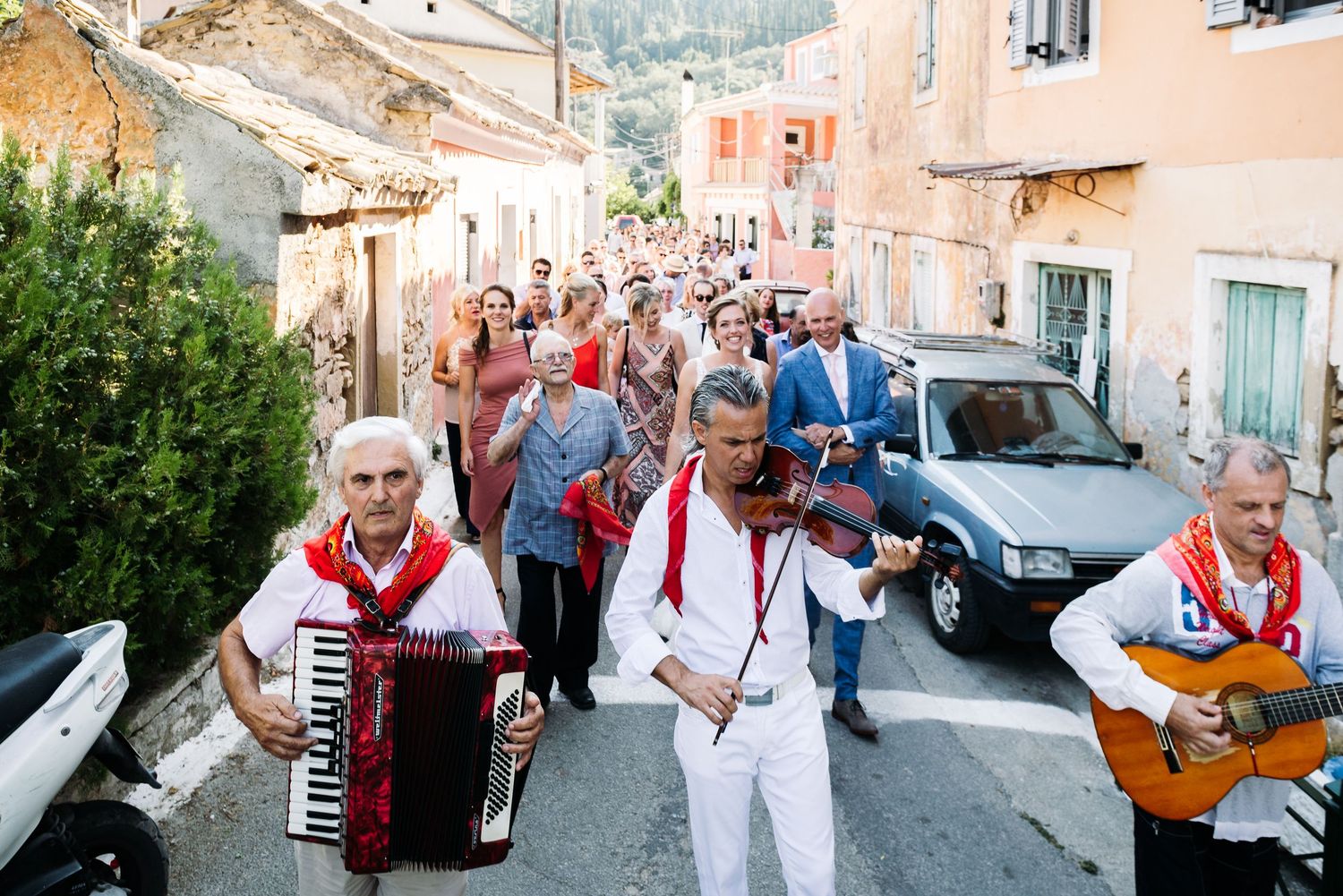 Musicians playing traditional instruments along a charming Mediterranean street during a celebration.