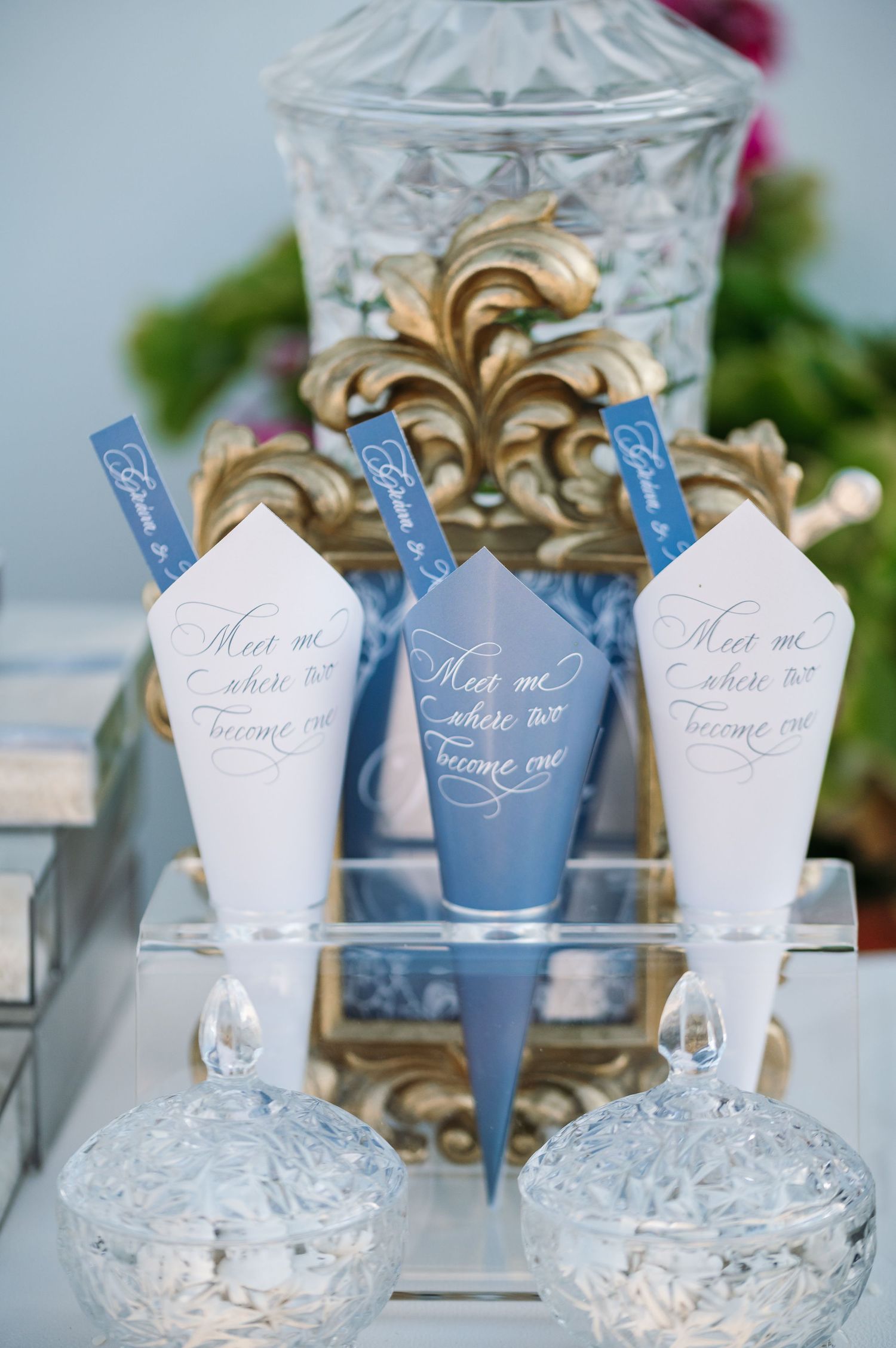 Wedding favors and decorative crystal glasses with blue and white name cards.