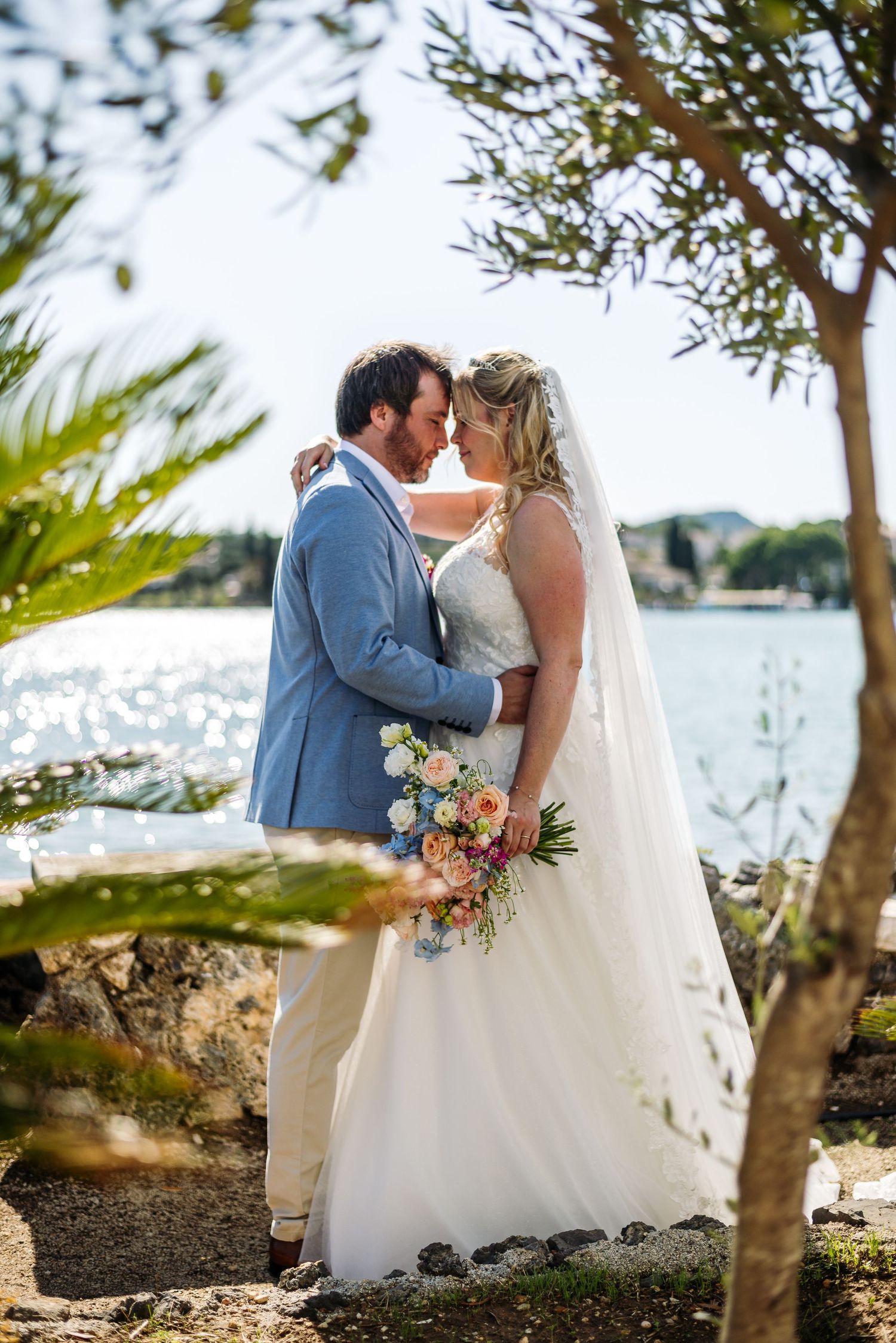 Intimate wedding couple portraits by the sparkling Mediterranean sea.