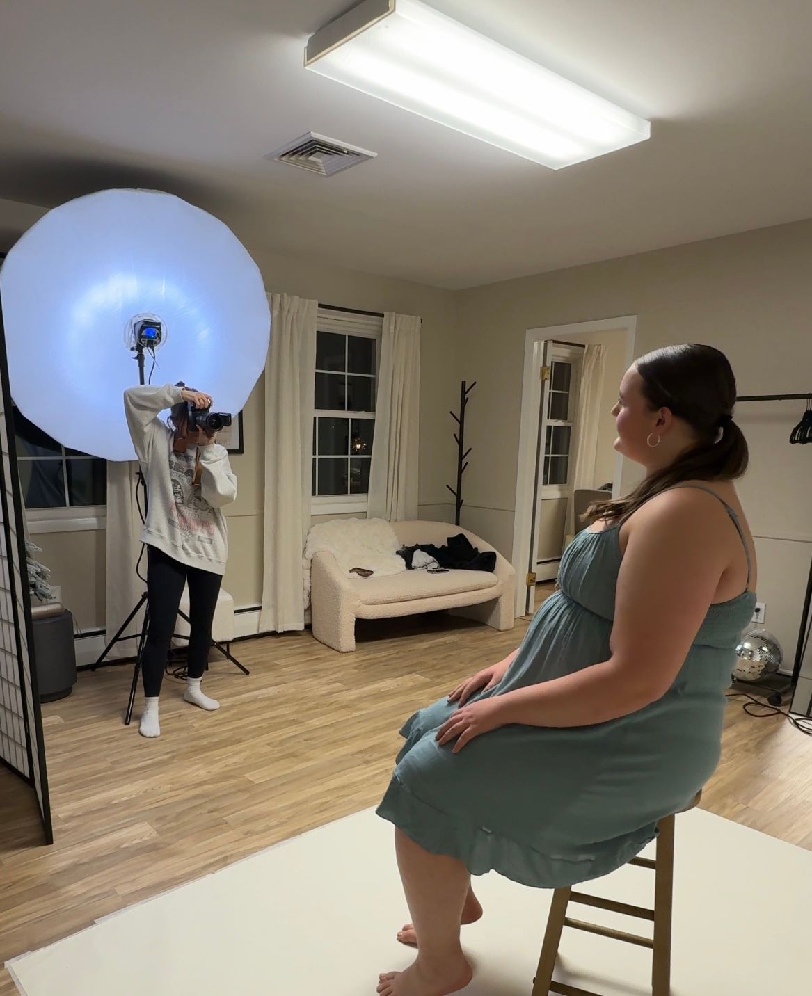Behind-the-scenes photo shoot setup with lighting equipment in dance studio.
