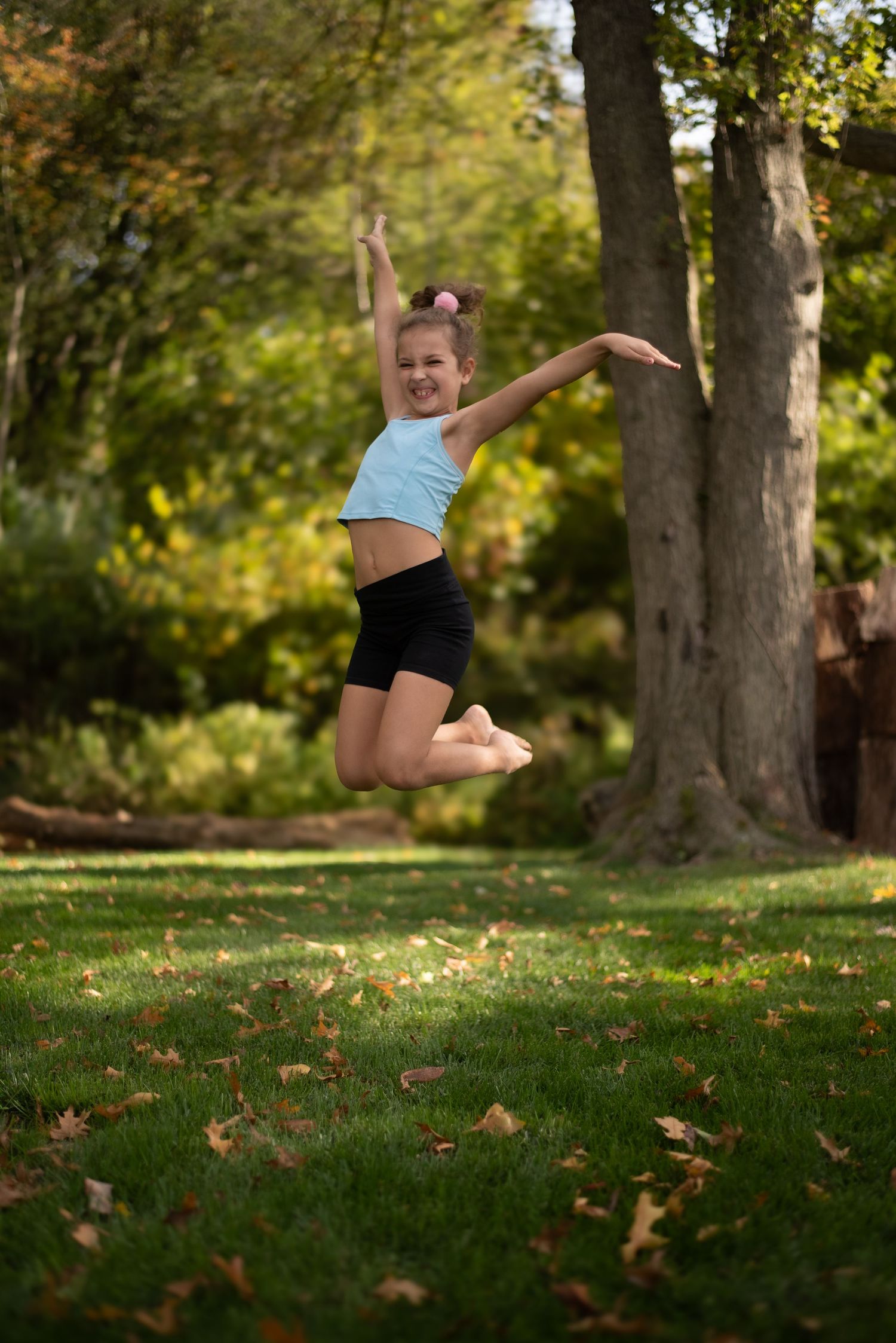 Dynamic leaps and jumps captured in outdoor park setting with autumn trees.