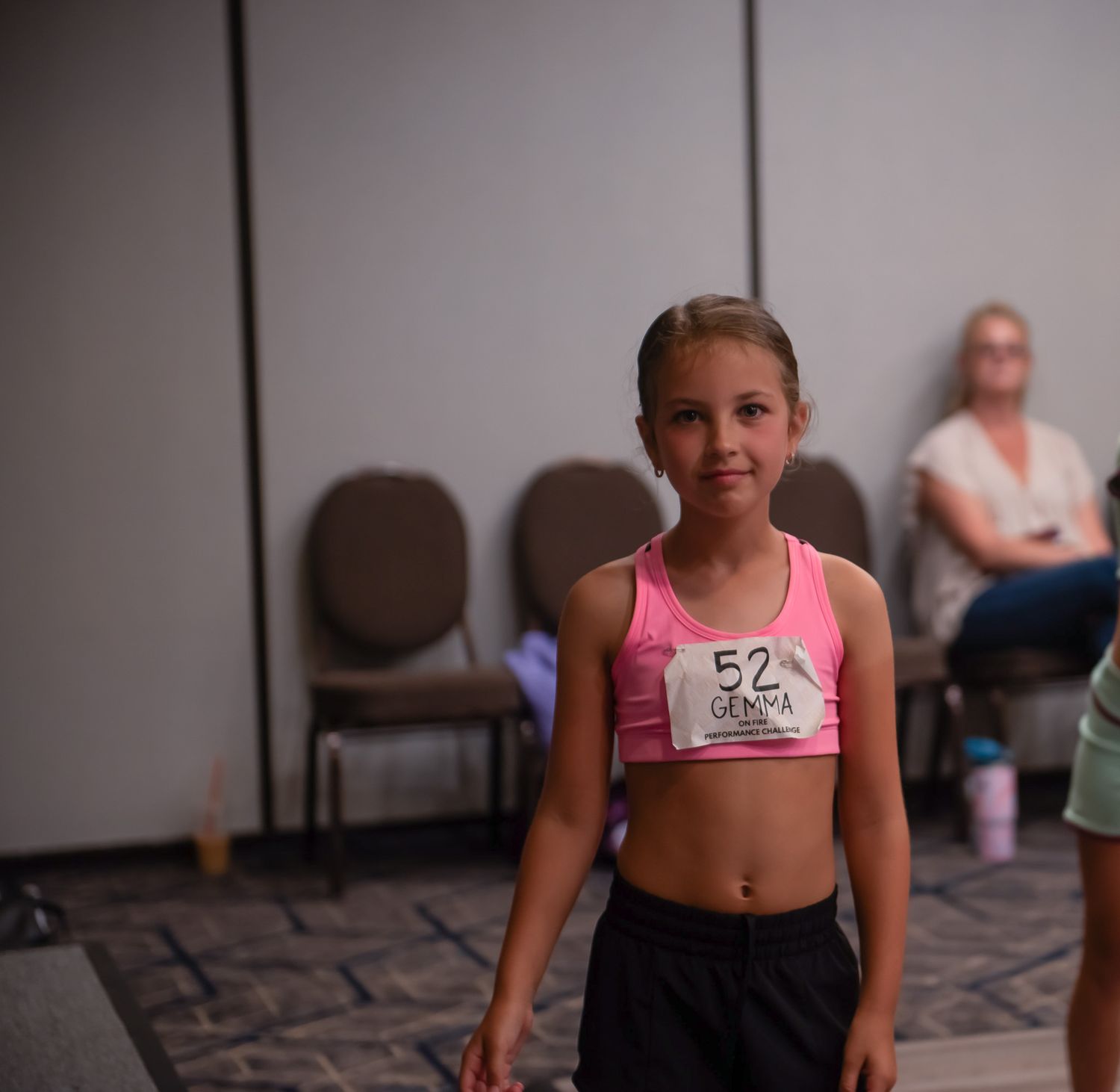 Young dancers in pink and black attire practicing in a dance studio.
