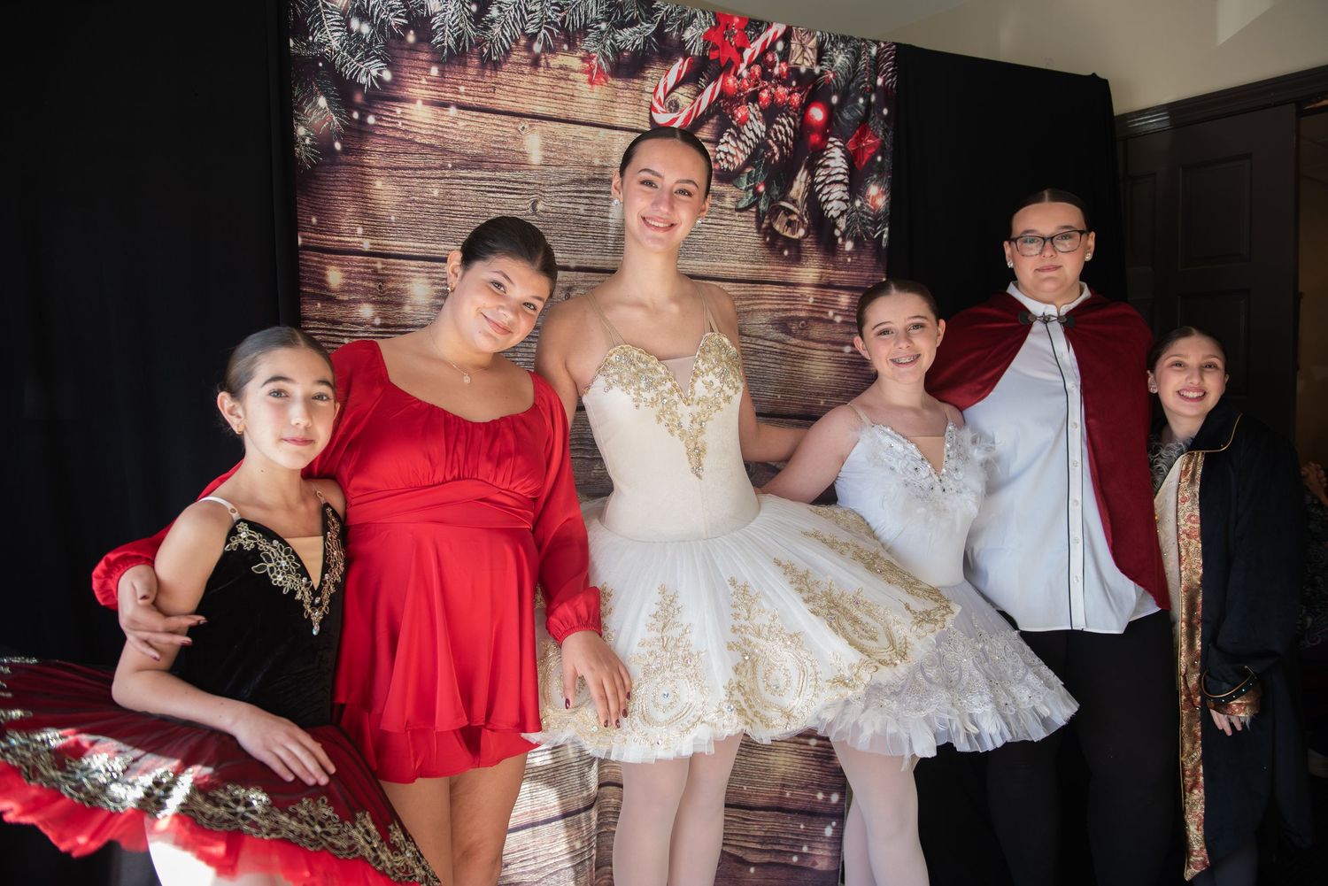 Group of dancers in red and white costumes posing together.