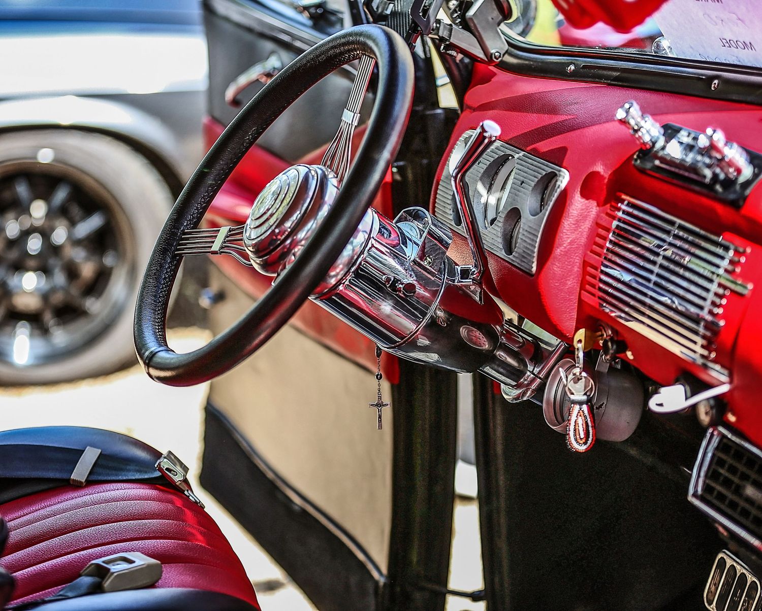Car Show event with Close-up shots of vintage car dashboard details showing chrome knobs, gauges and steering wheel components.