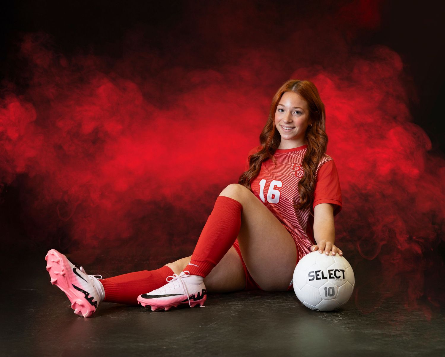 Dramatic sports portrait series with red smoke effects and volleyball equipment against dark background.
