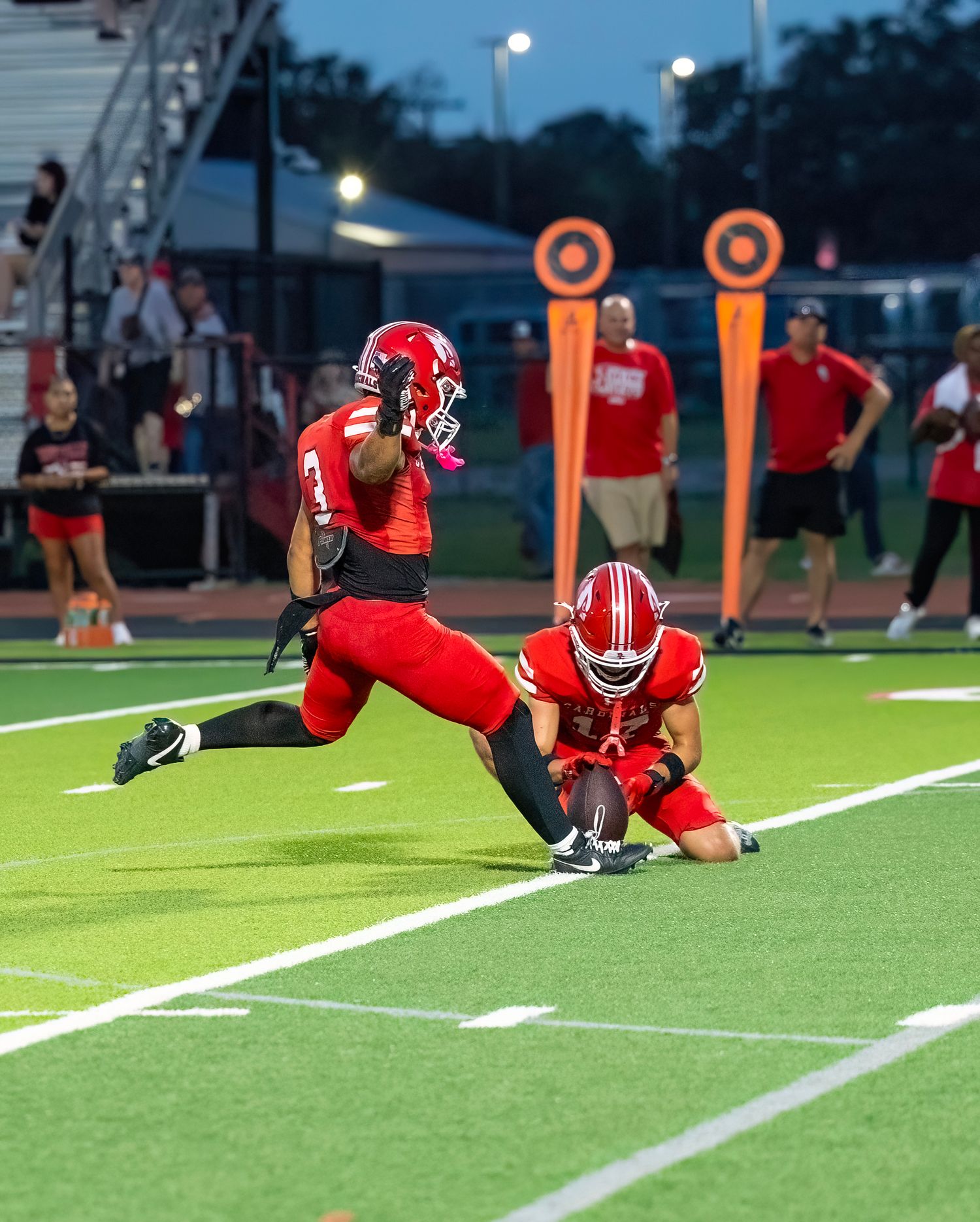 Football players diving and sliding across the turf field during a game.