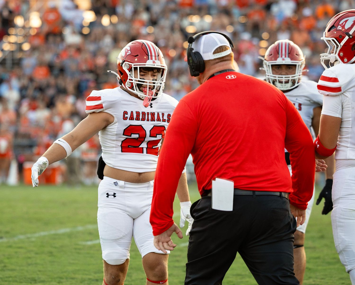 Football players and coaches gathered on the sidelines during a game.