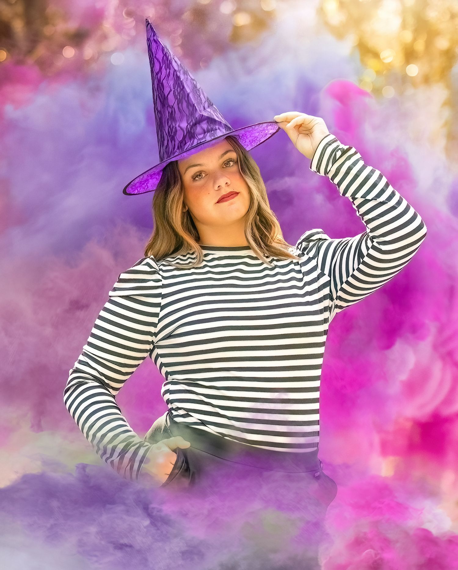 A striped top and purple witch hat emerge through colorful smoke effects outdoors.