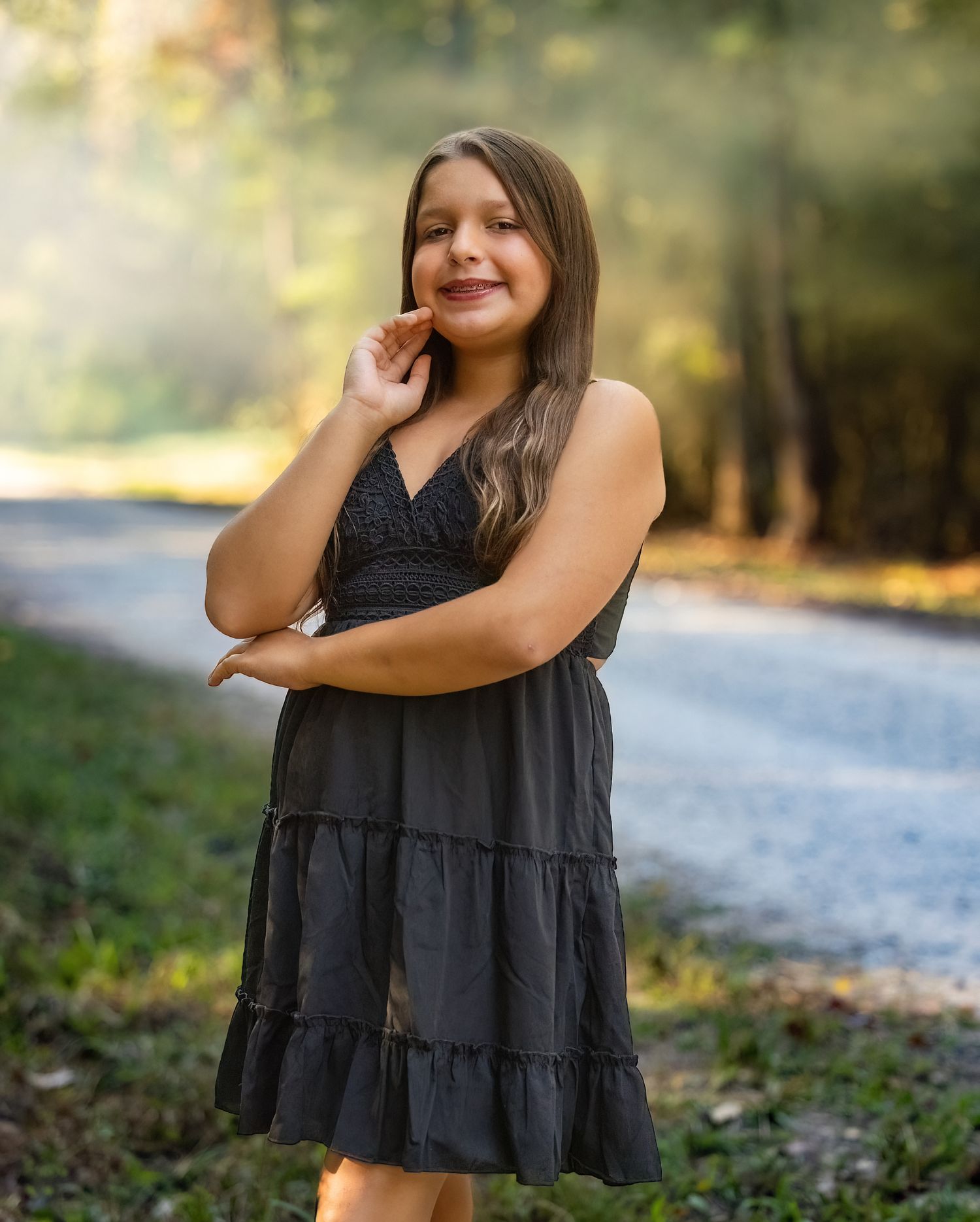 A sequence of casual outdoor portraits featuring a black sleeveless tiered dress in a natural setting.