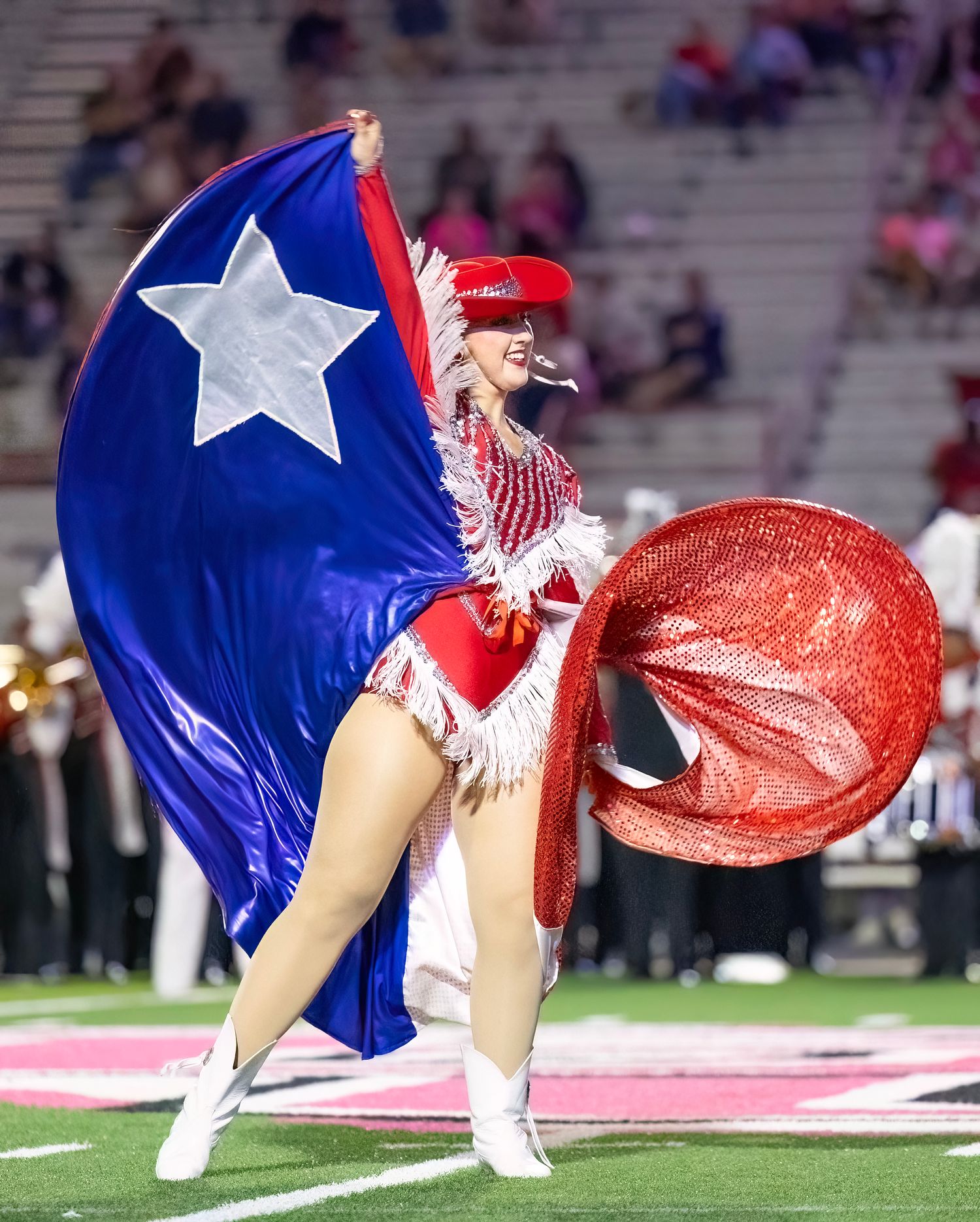Dance team members in red and blue star-spangled costumes perform during a halftime show.