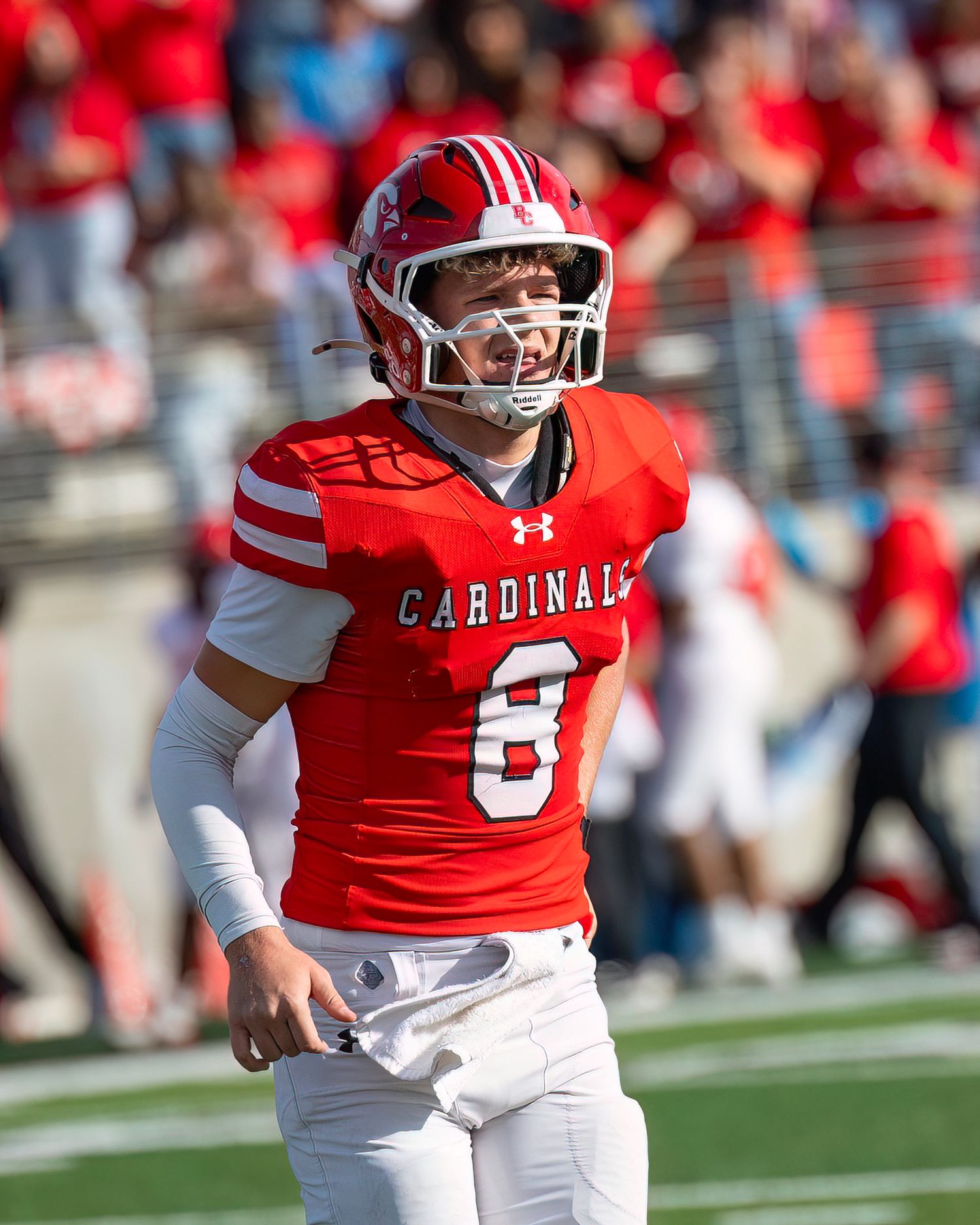 Cardinals player in red and white uniform with number 8 stands on football field during game.