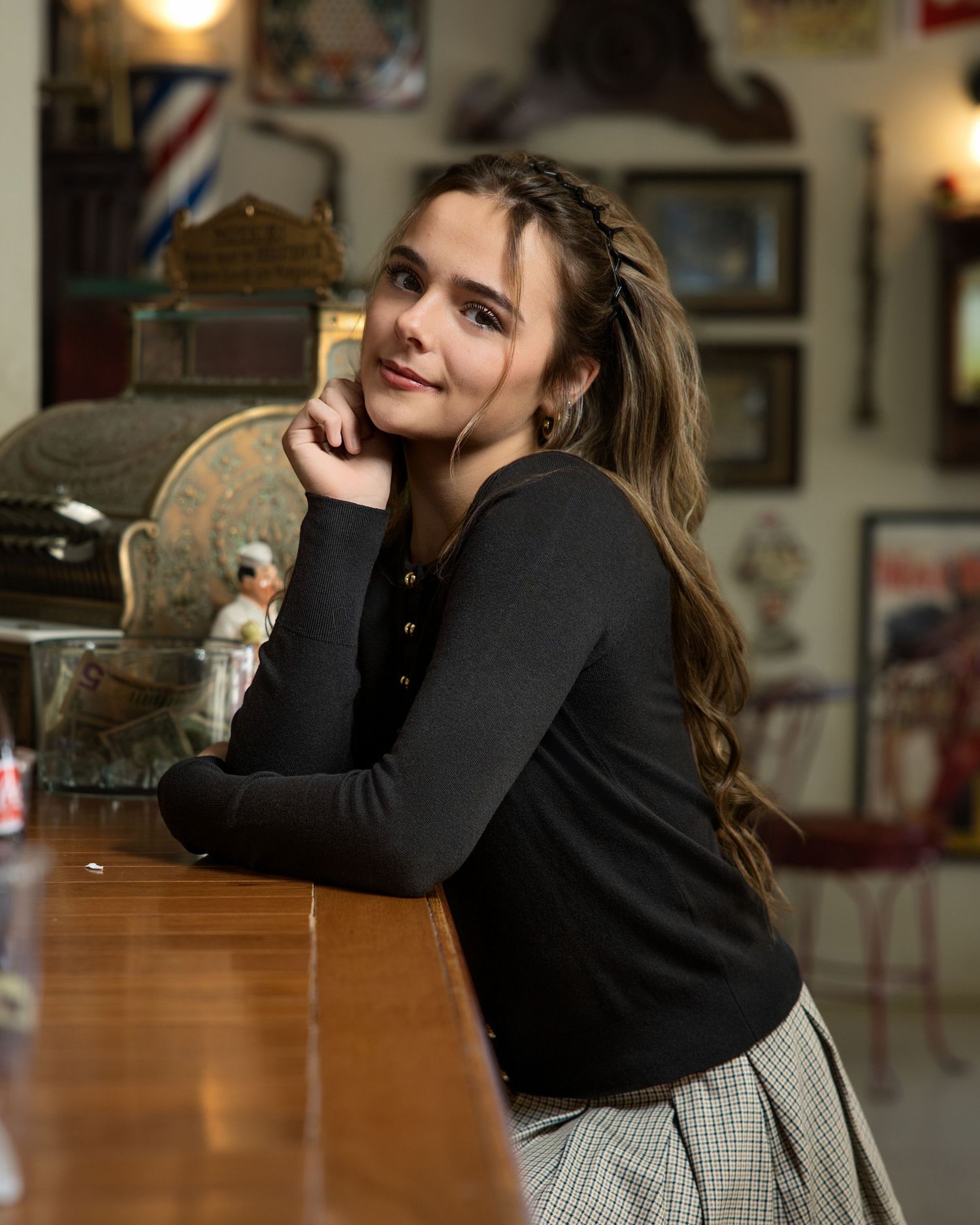 Indoor portrait session with black sweater at a rustic wooden table.
