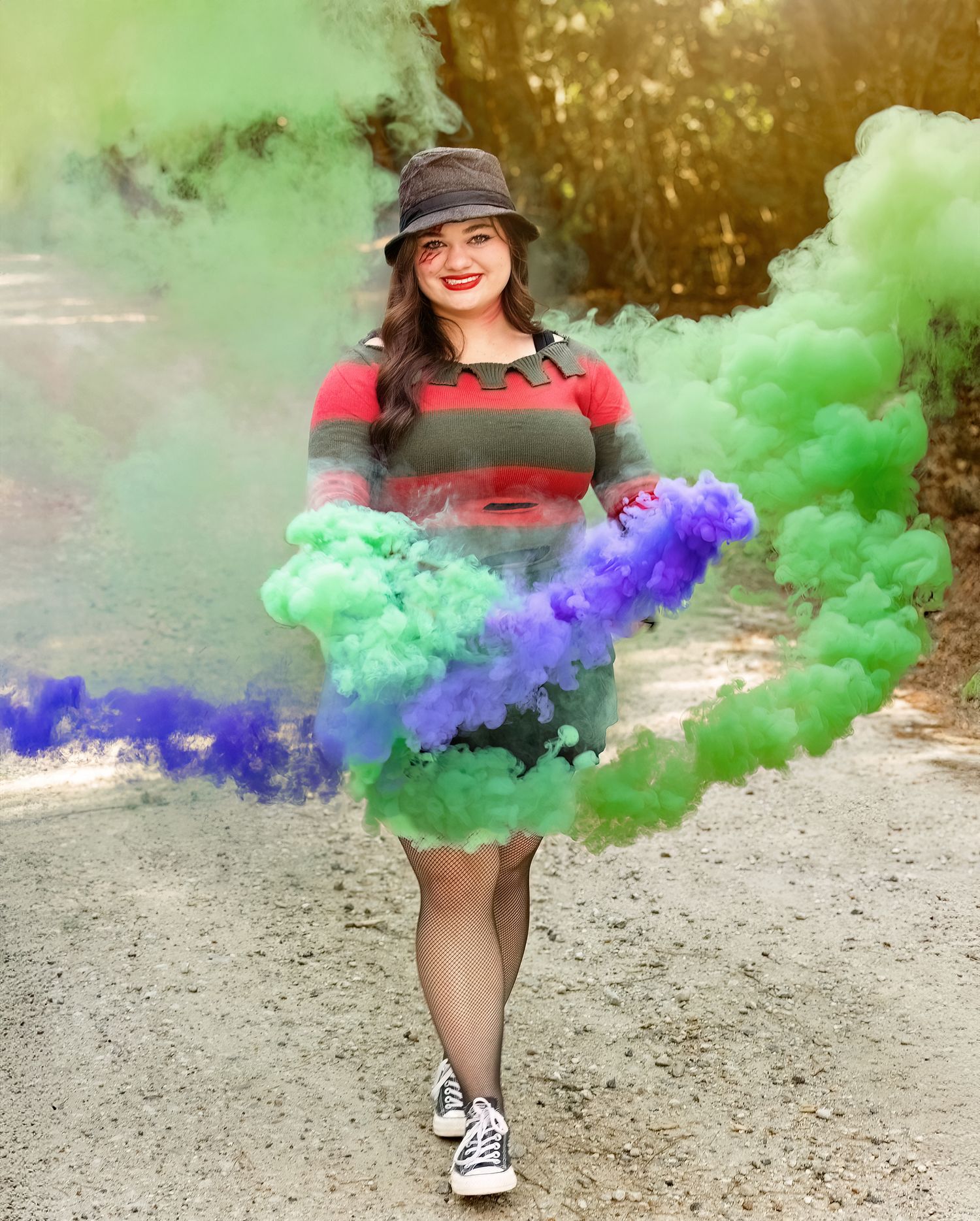 A person in a striped dress and hat poses on a path surrounded by green and purple smoke effects.