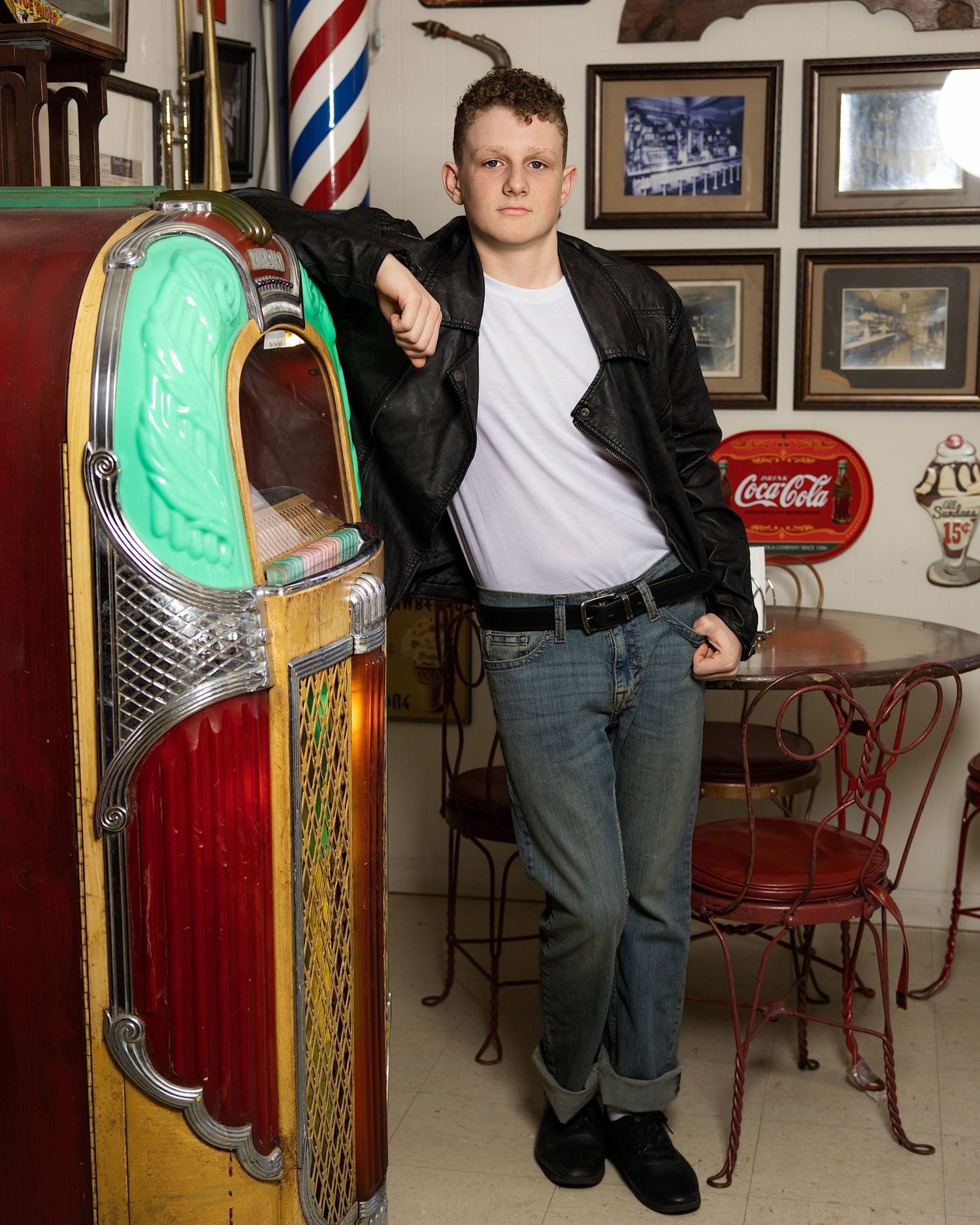 Retro-inspired portrait next to a vintage jukebox in classic 1950s greaser style.