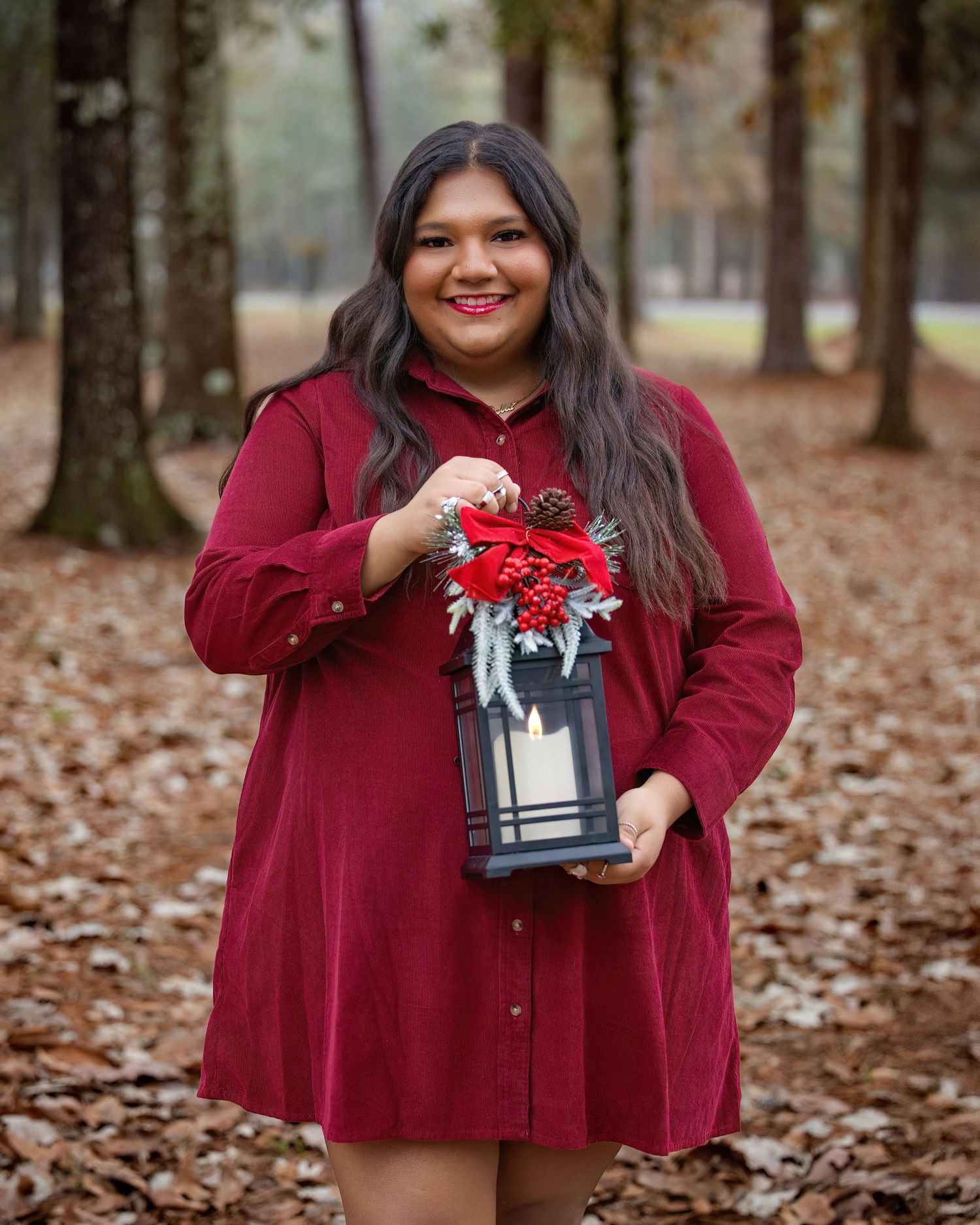Izabella a PNG Senior poses with a silver gift box on fallen autumn leaves.