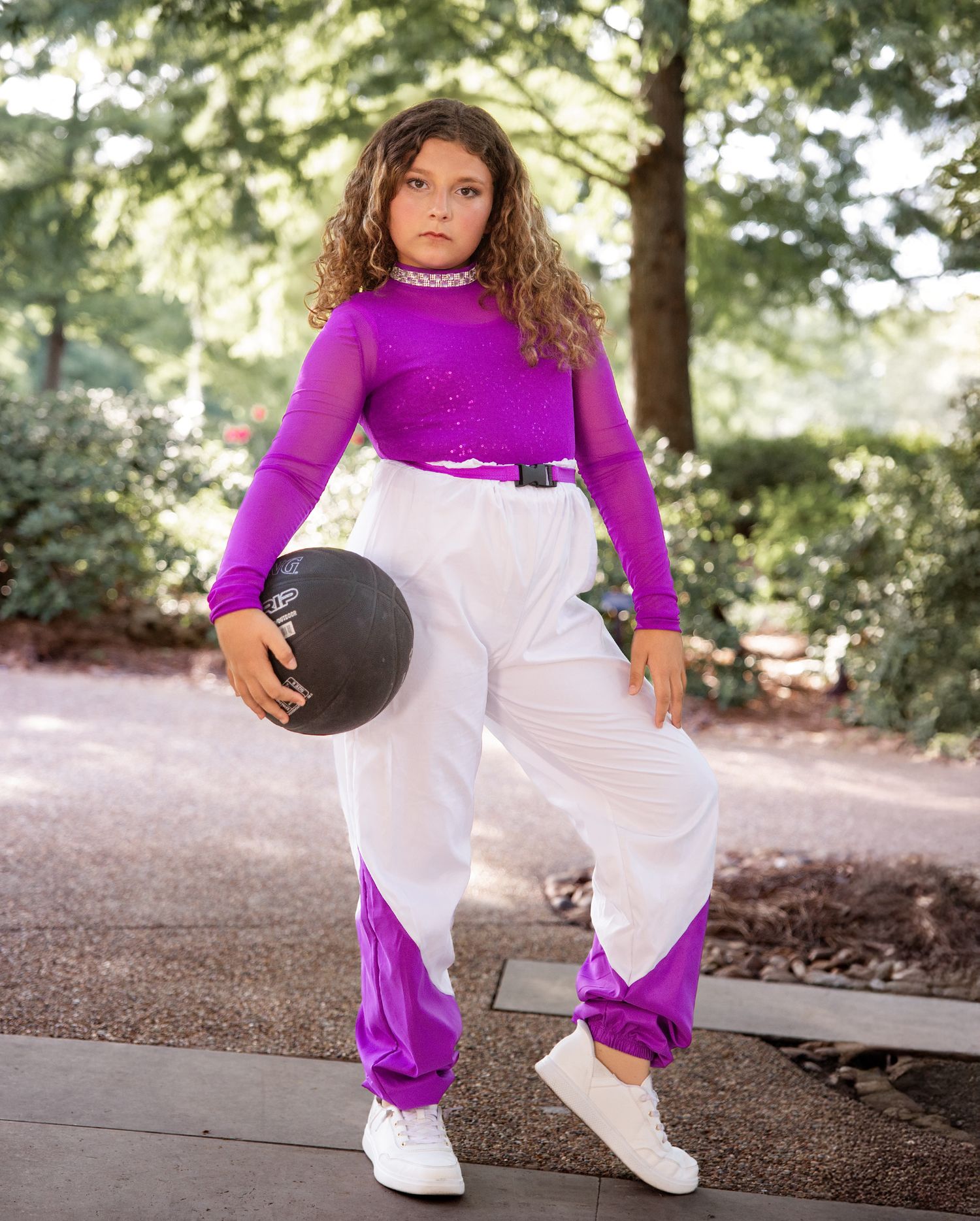 A sequence of photos showing someone in a purple top and white pants holding a basketball in various poses outdoors.