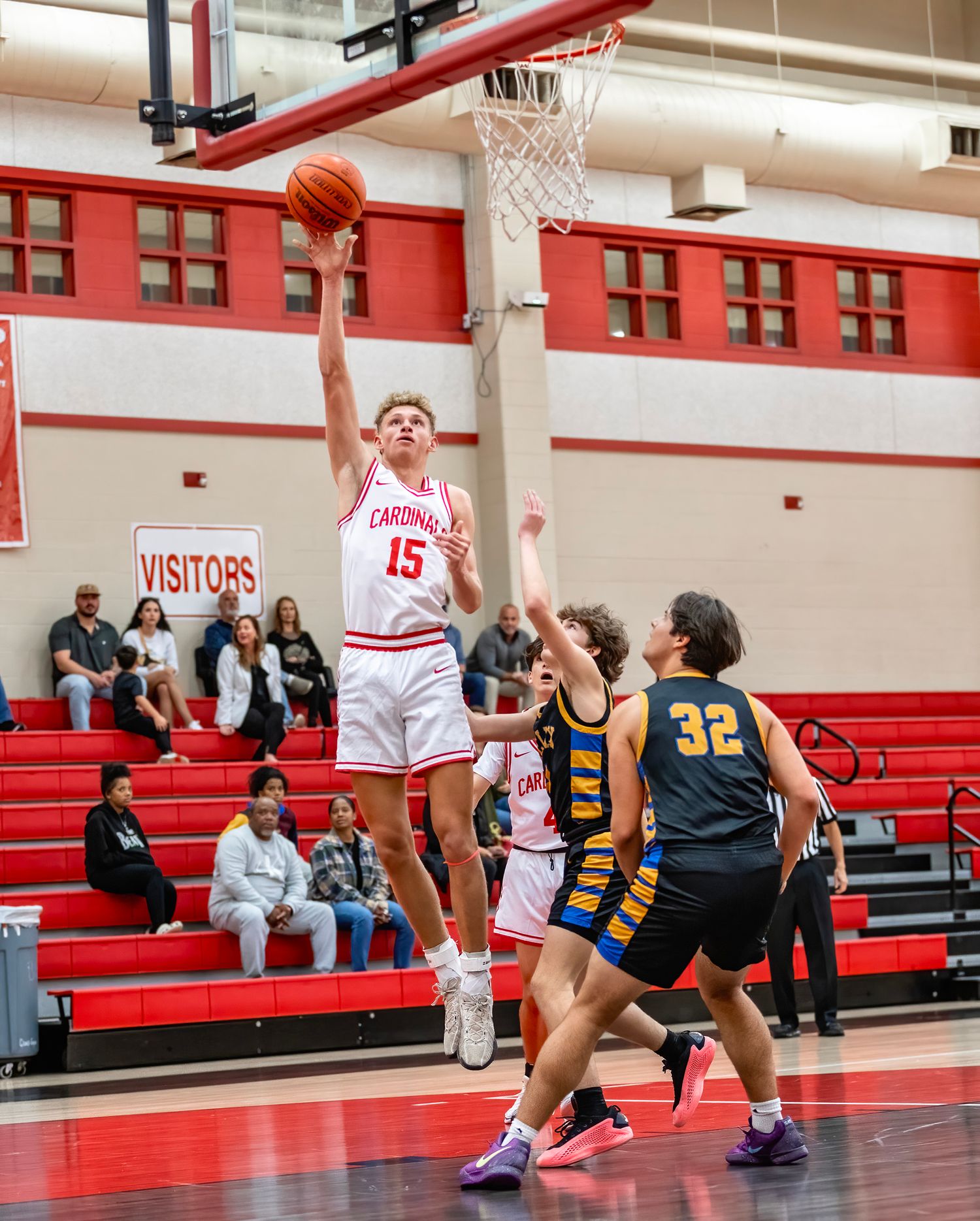 Game highlights with Bridge City High school basketball game in progress with players in white and navy uniforms competing on the court.