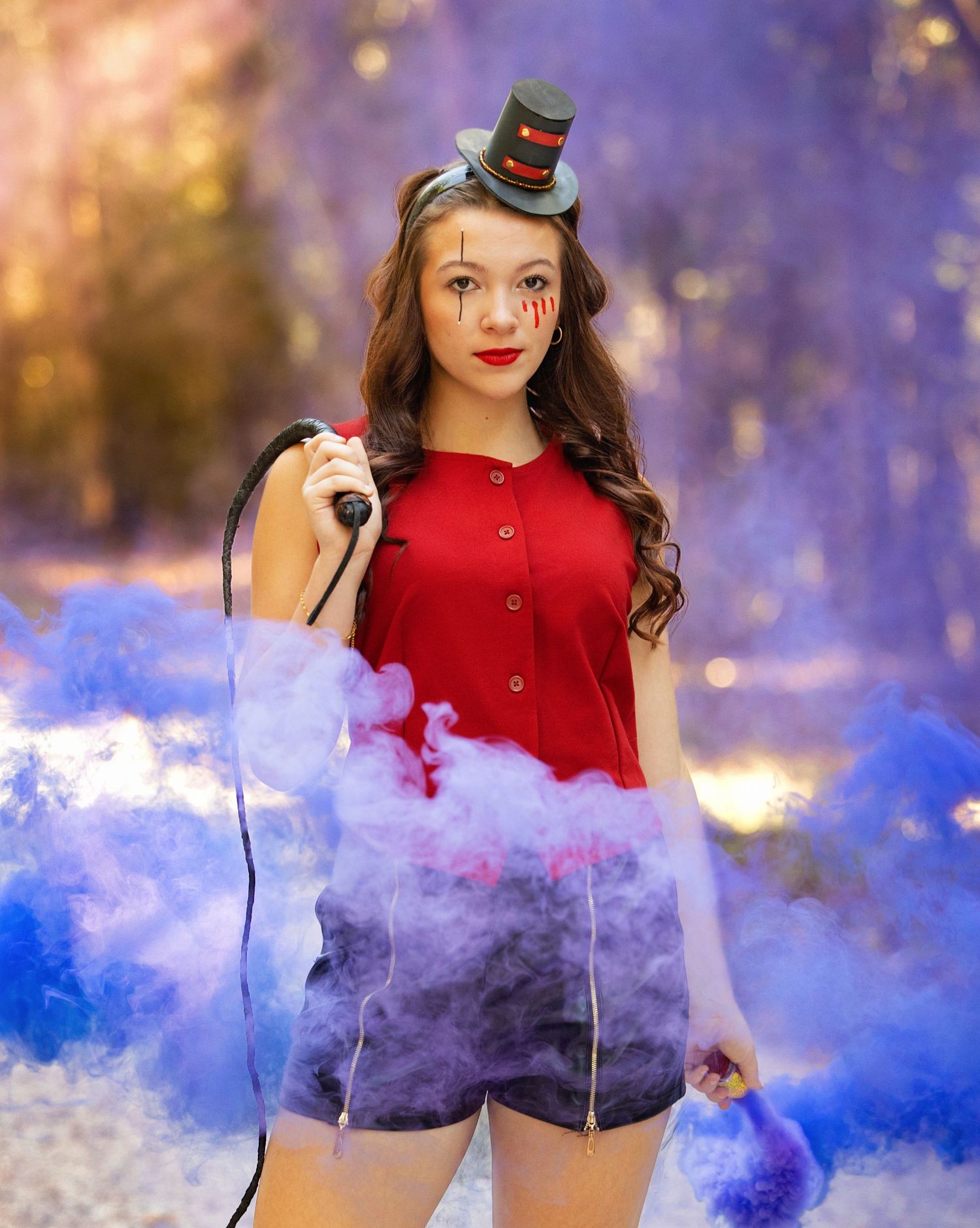 Creative photoshoot with red and blue smoke bombs creating vibrant color effects in a forest setting.