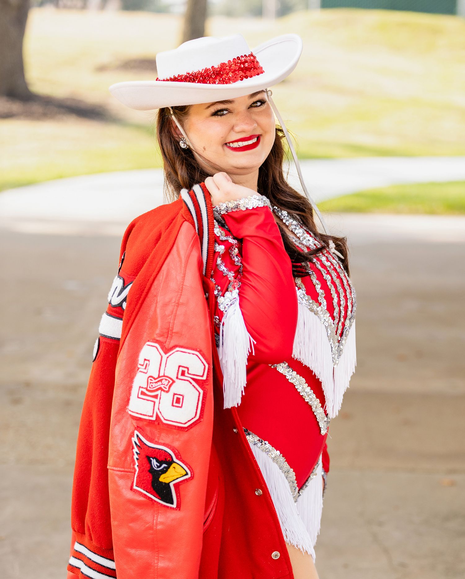 Bridge City High School Senior Eisley  wearing red and white team gear shows school spirit outdoors.